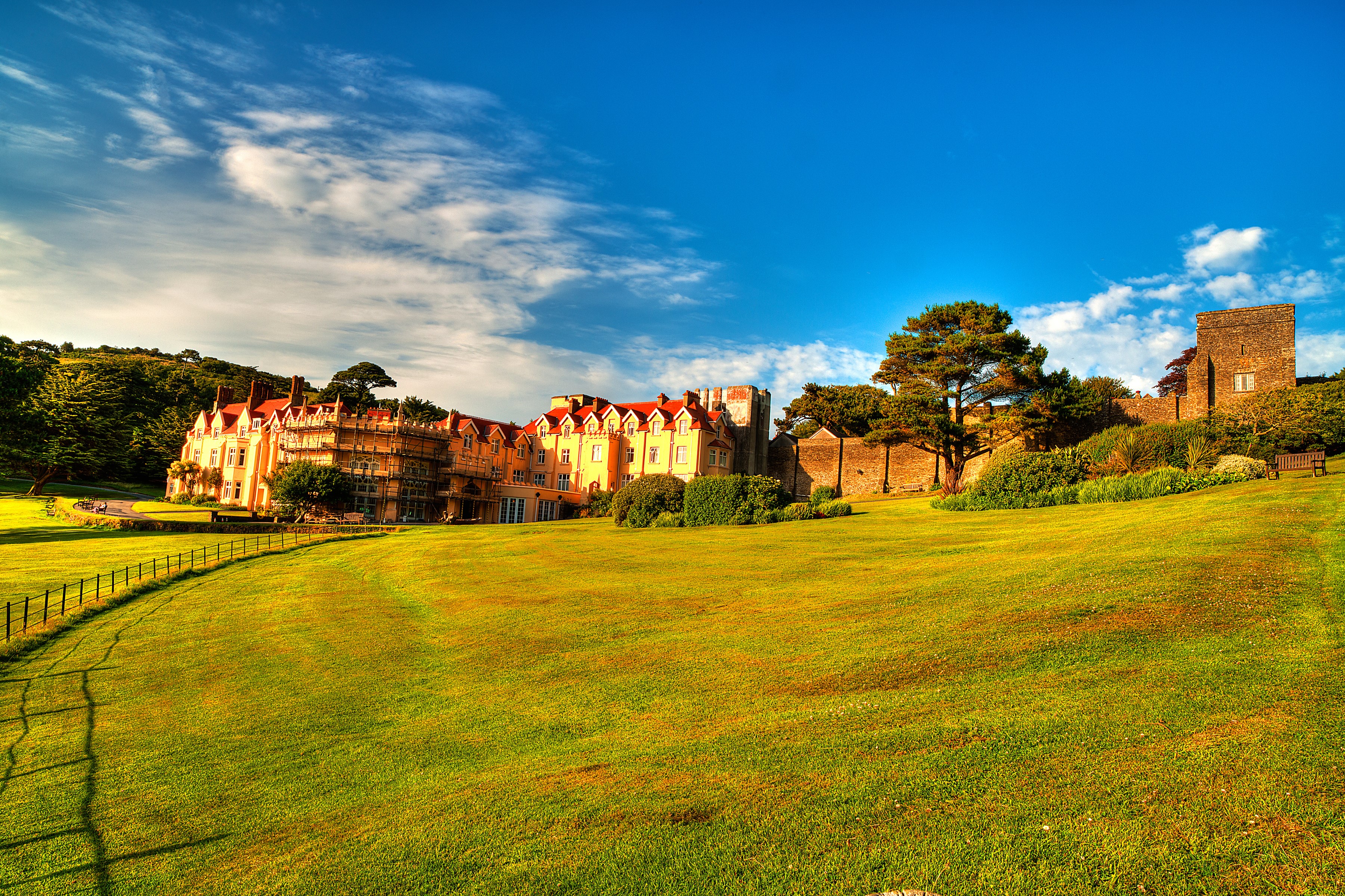 Castle and manor house on a grassy hill in Exmoor, England HD Wallpaper