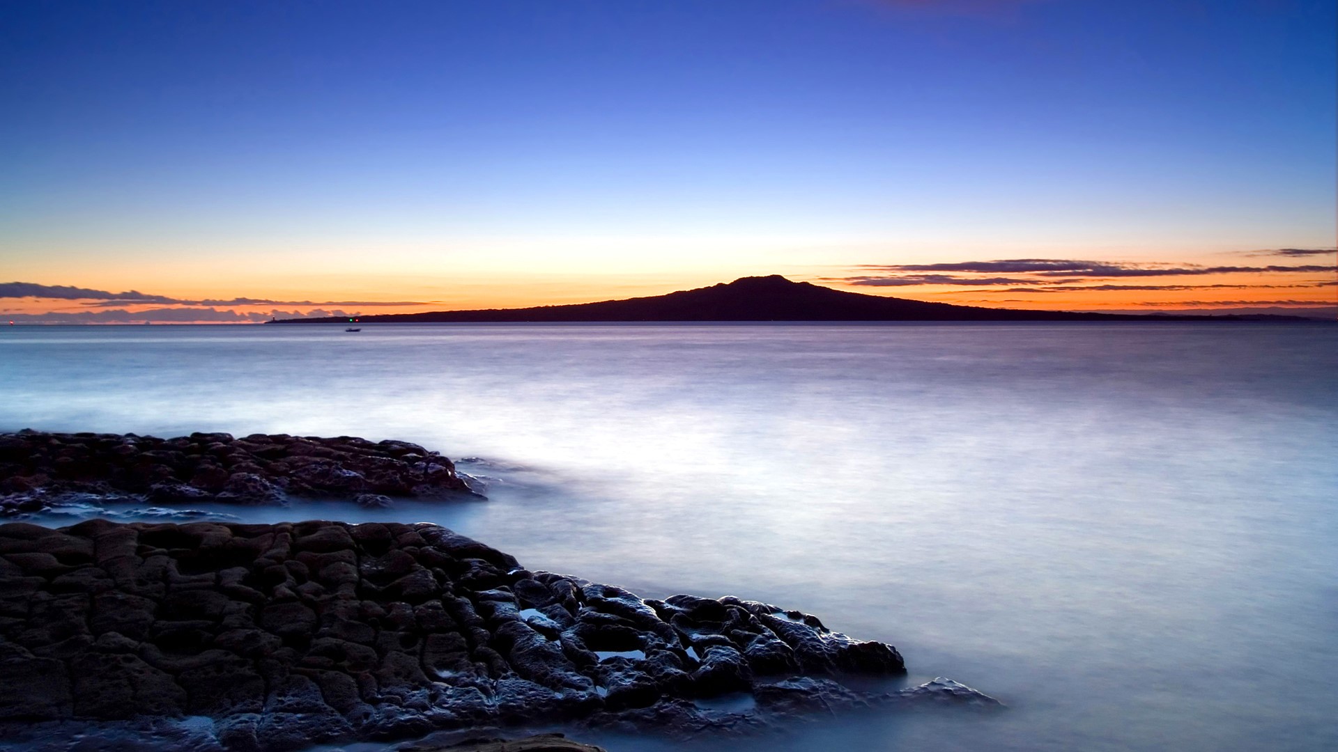 Ocean coast at sunset with island silhouette HD Wallpaper
