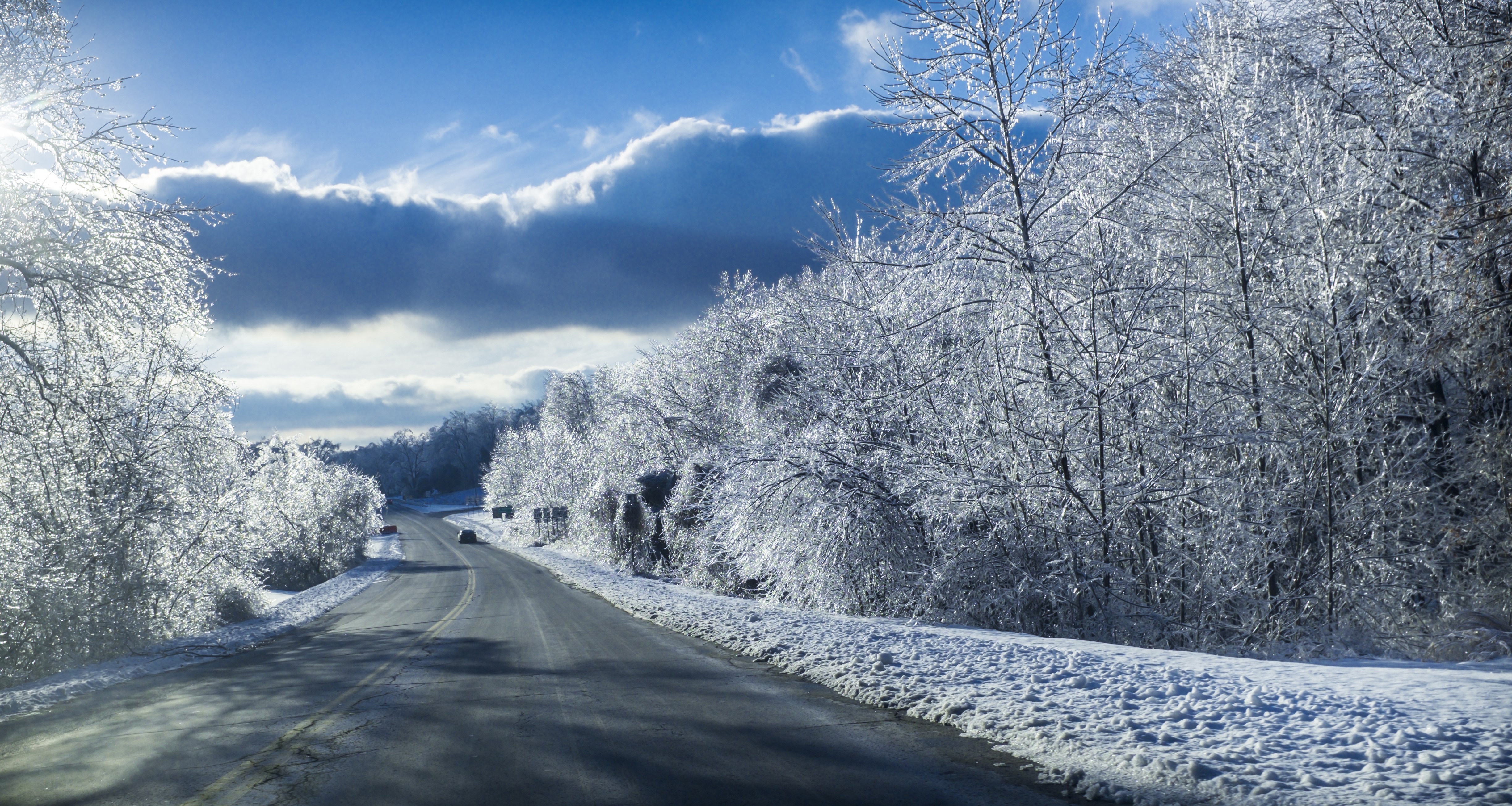 Road in Winter with Ice-Covered Trees and Clouds HD Wallpaper