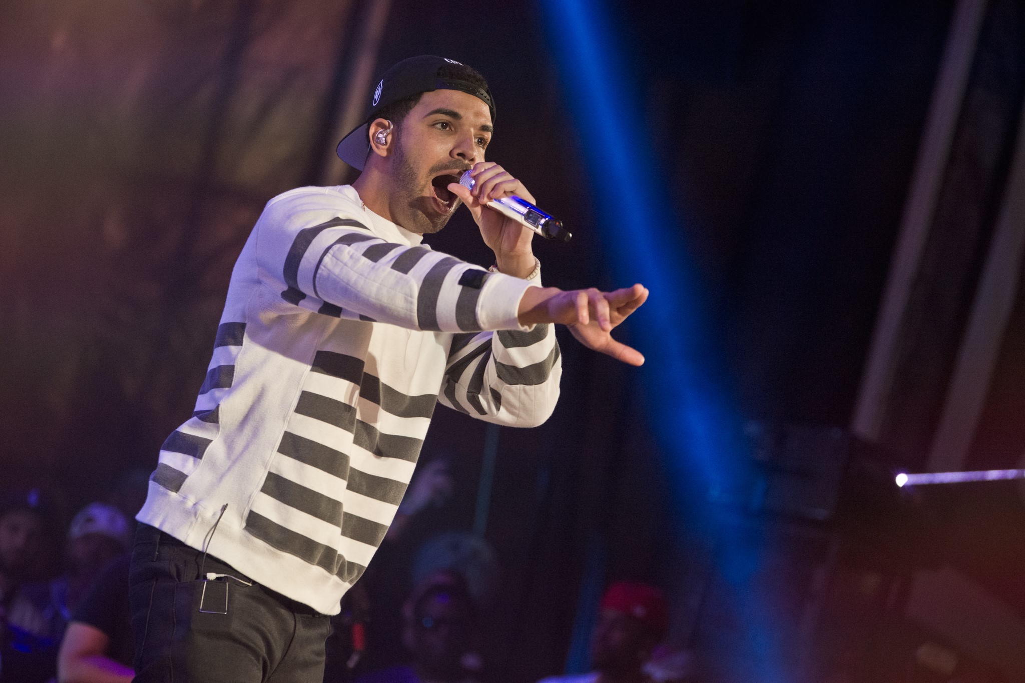 Drake performing on stage with microphone HD Wallpaper