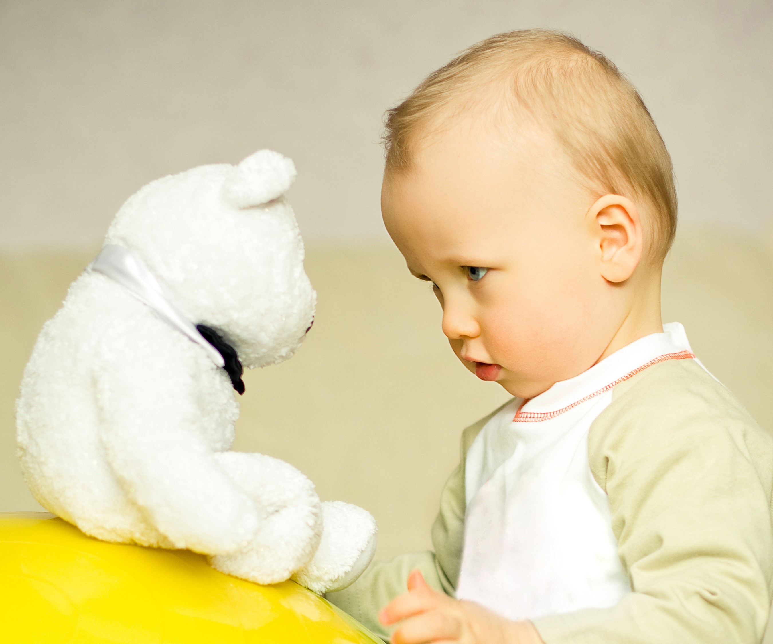 Baby looking at a white teddy bear HD Wallpaper