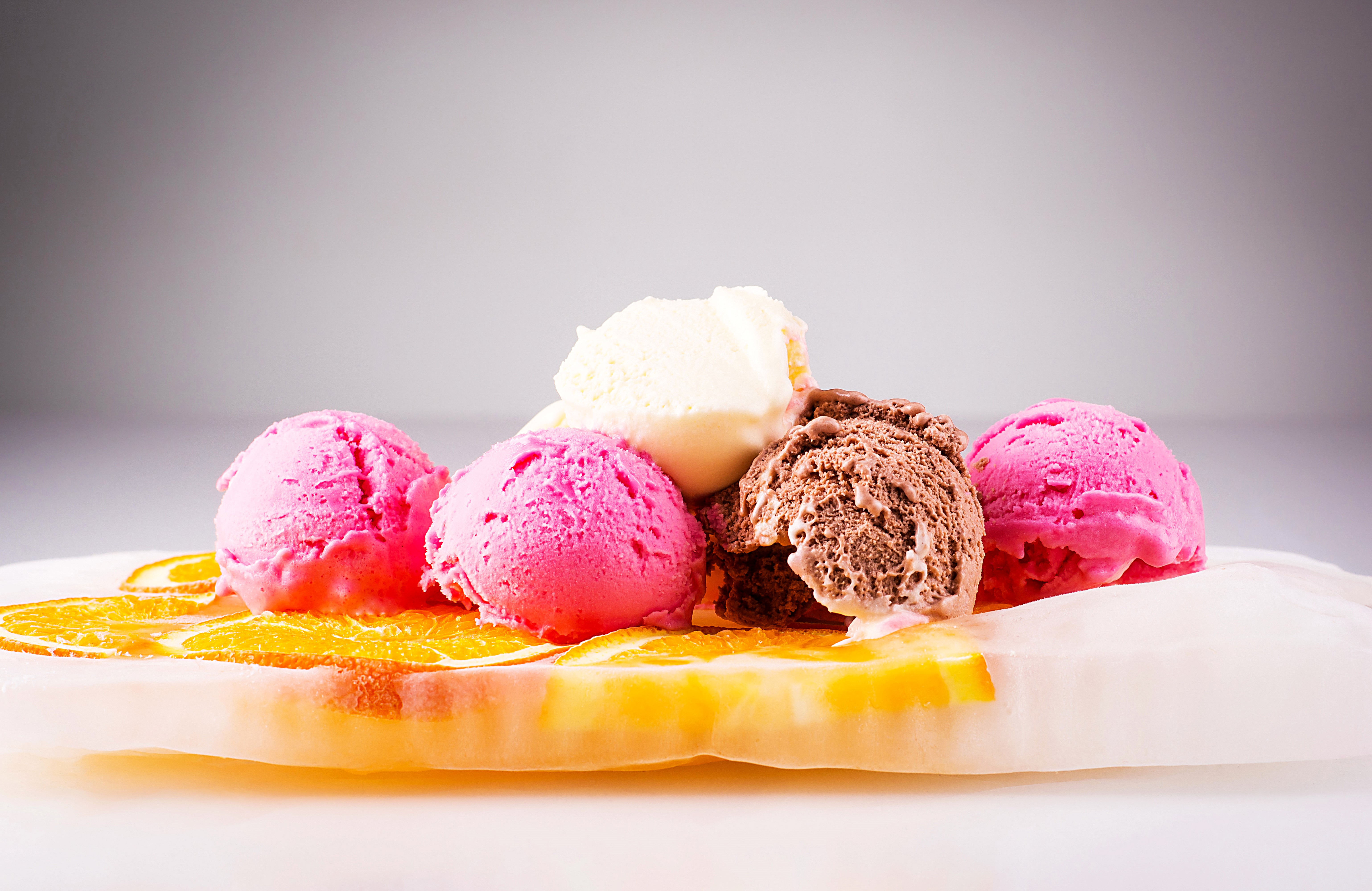Assortment of Ice Cream Scoops on Orange Slices HD Wallpaper