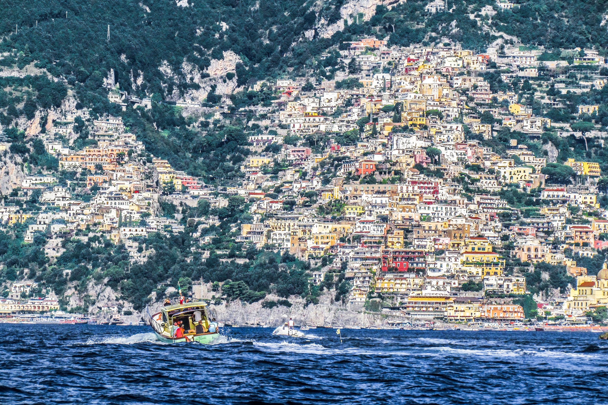 Positano, Italy: Houses on a steep mountain overlooking the sea with a motorboat HD Wallpaper
