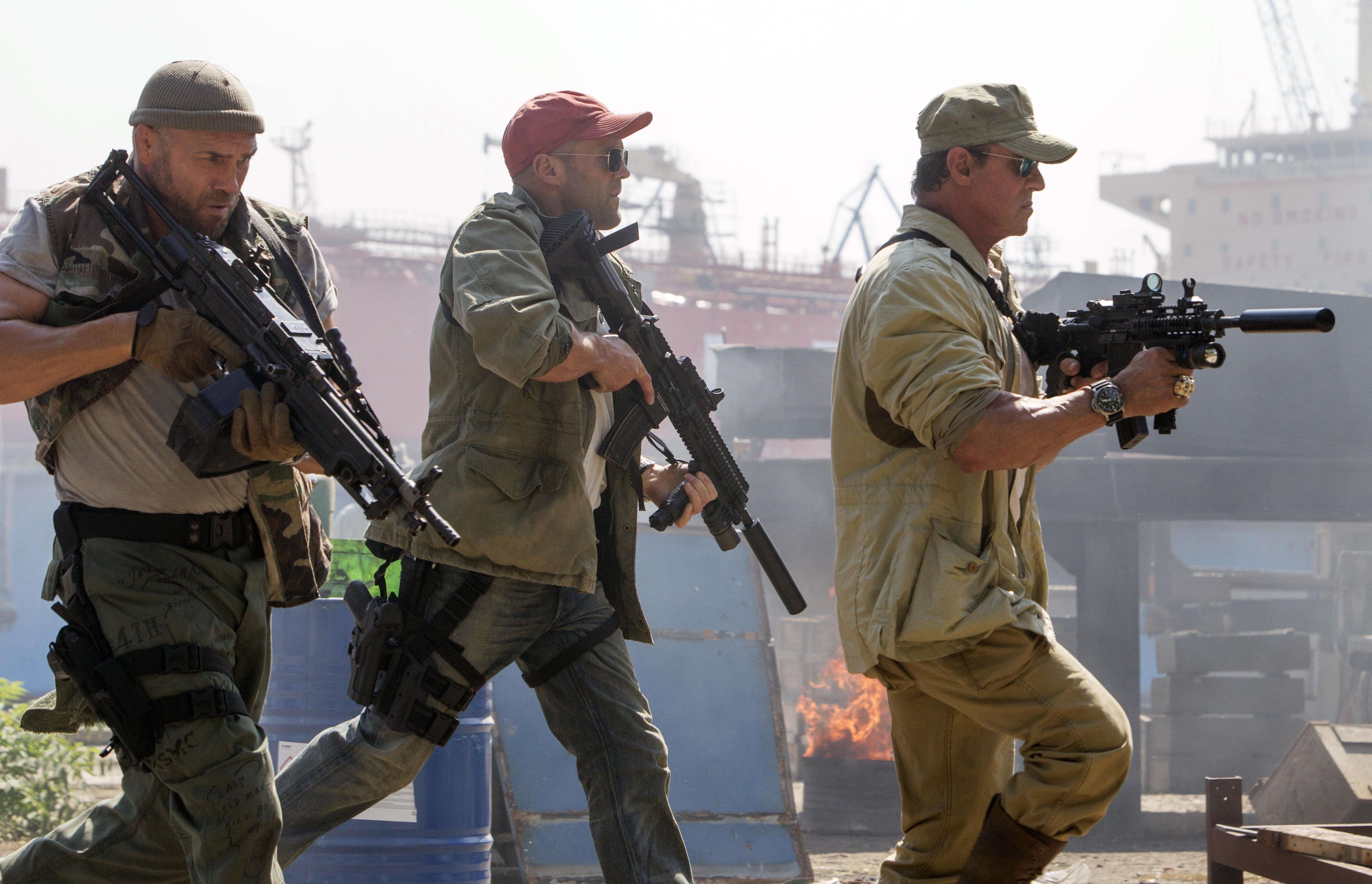 Sylvester Stallone, Jason Statham, and Randy Couture with assault rifles HD Wallpaper