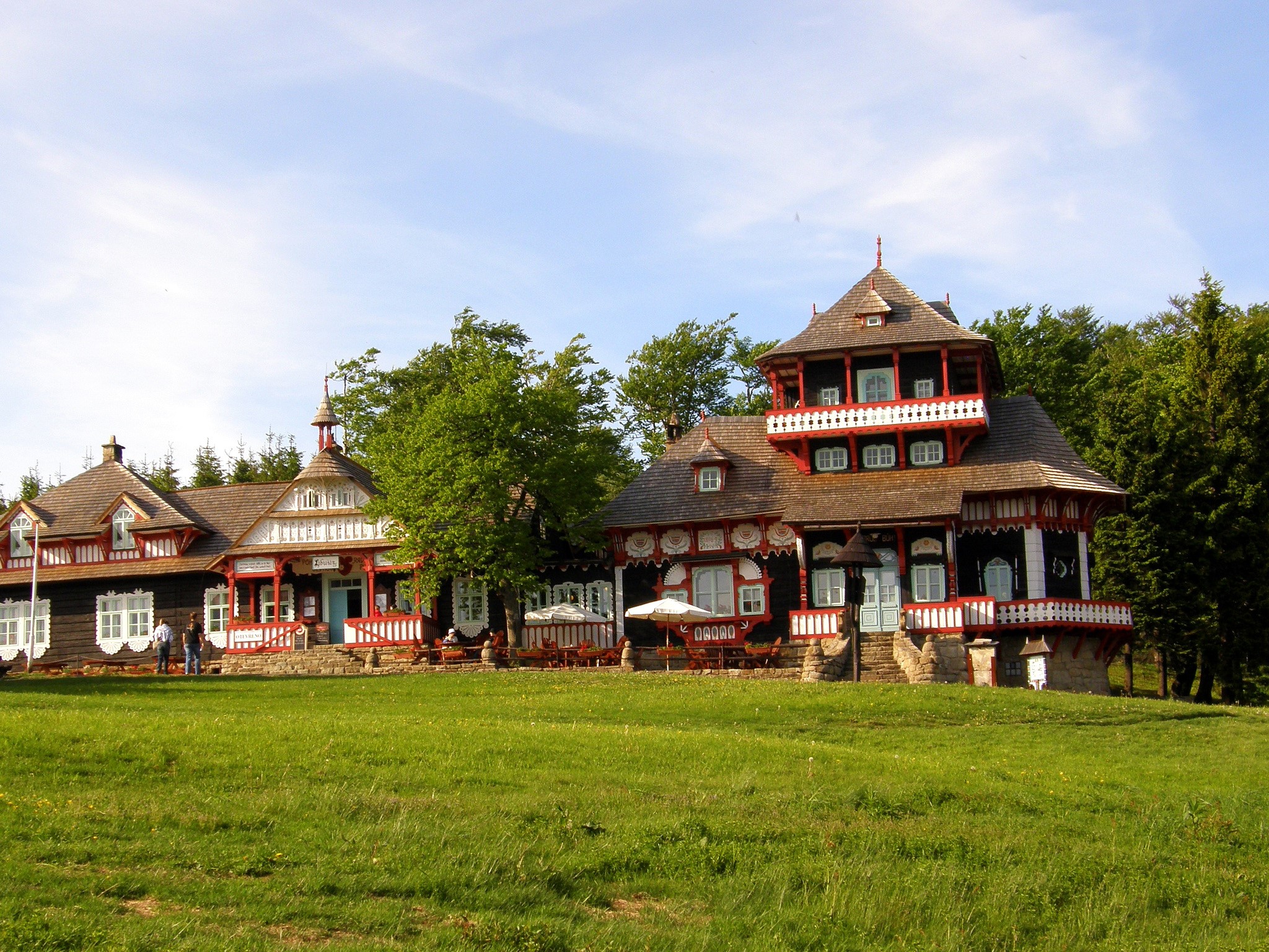 Traditional wooden houses in a grassy field HD Wallpaper