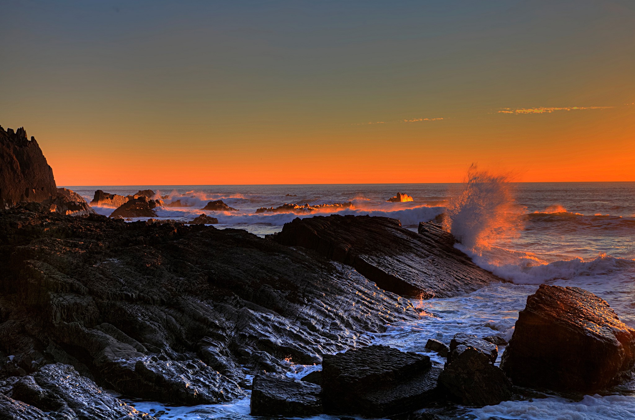 Sunset over rocky coast with waves crashing HD Wallpaper