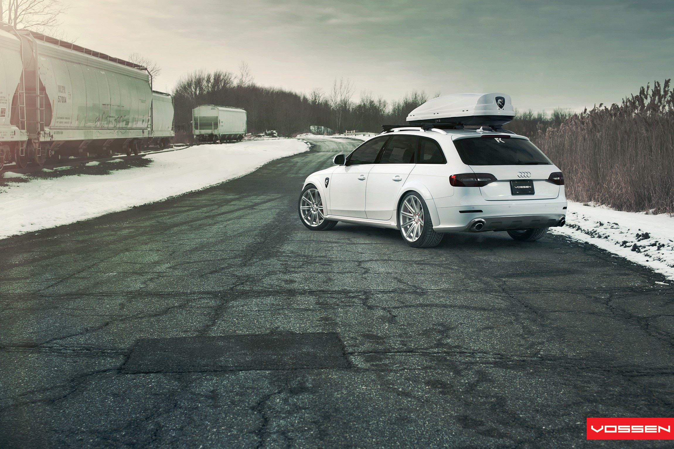 White Audi Station Wagon with Roof Box on Snowy Road HD Wallpaper