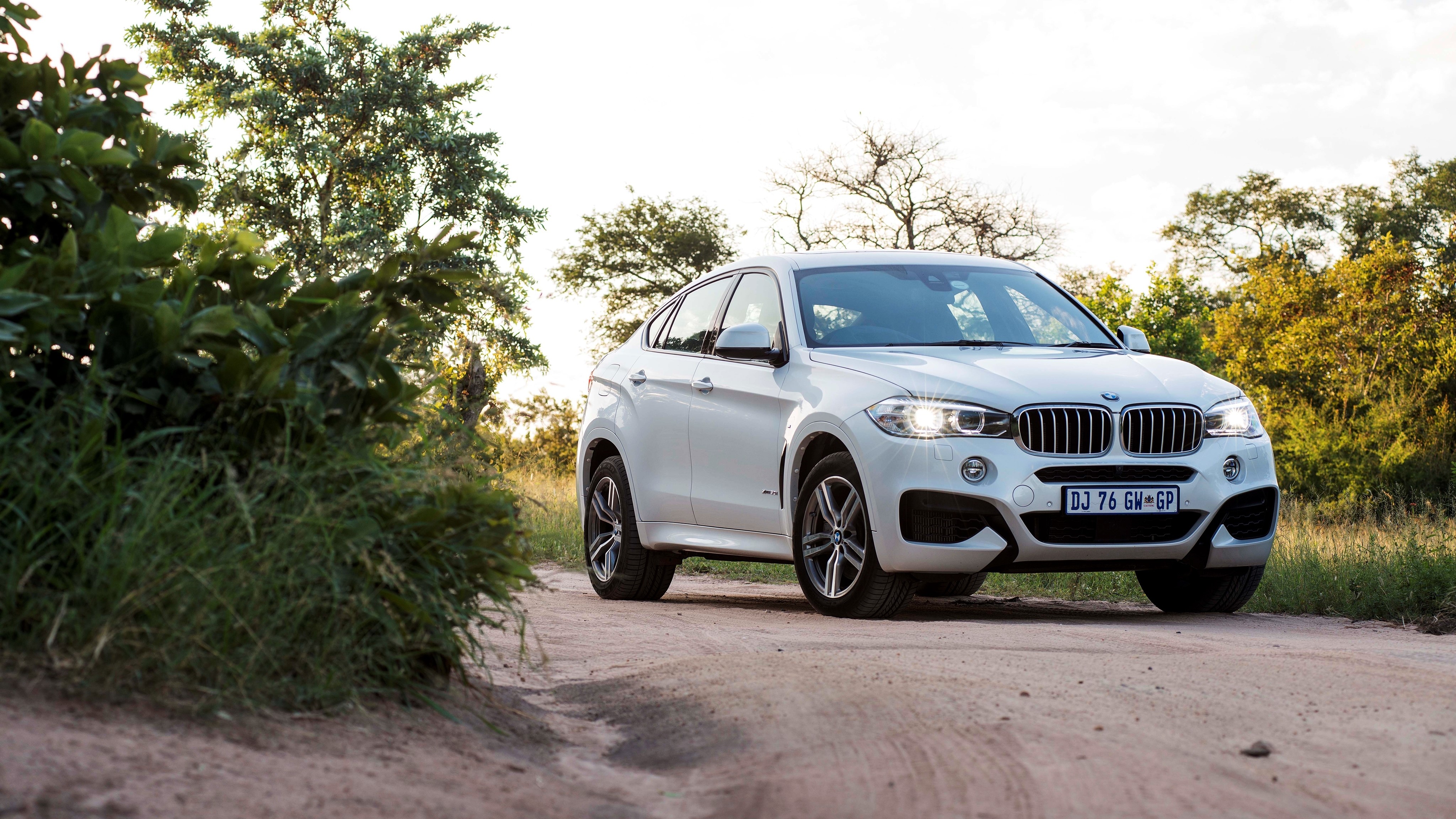 White BMW X6 xDrive on a dirt road HD Wallpaper