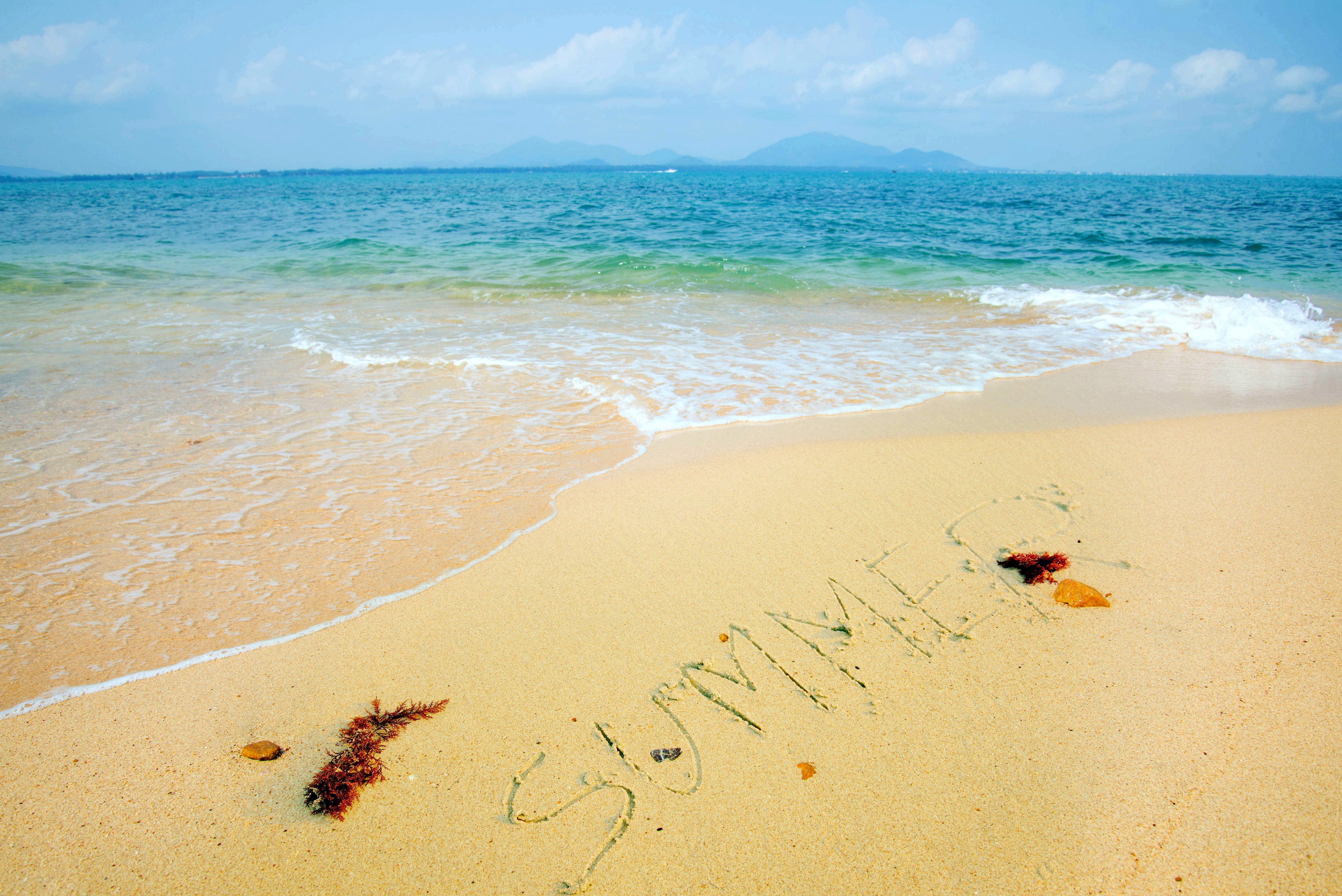 Summer written in sand on a beach with the ocean HD Wallpaper