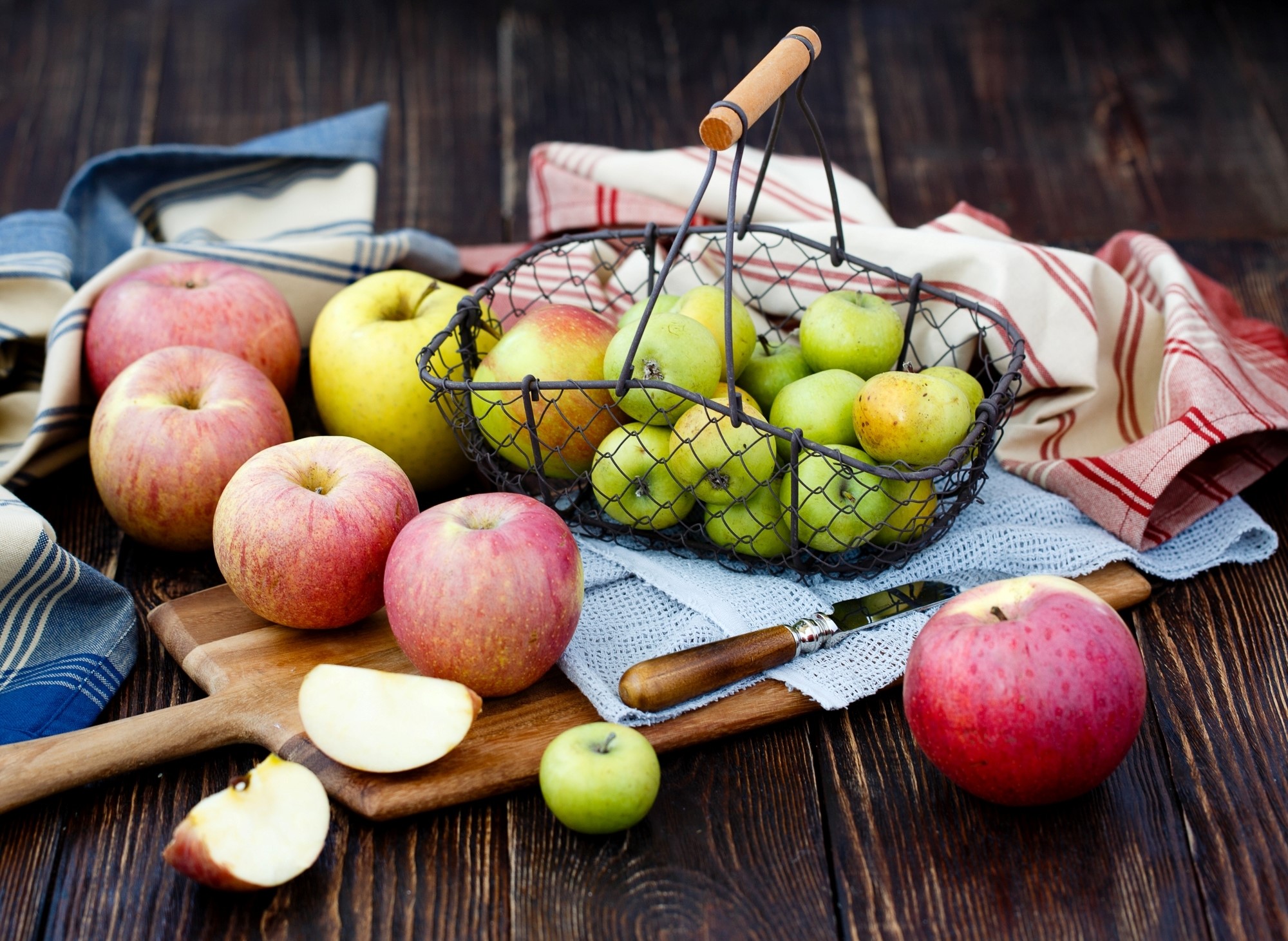 Apples in a basket on a wooden table HD Wallpaper