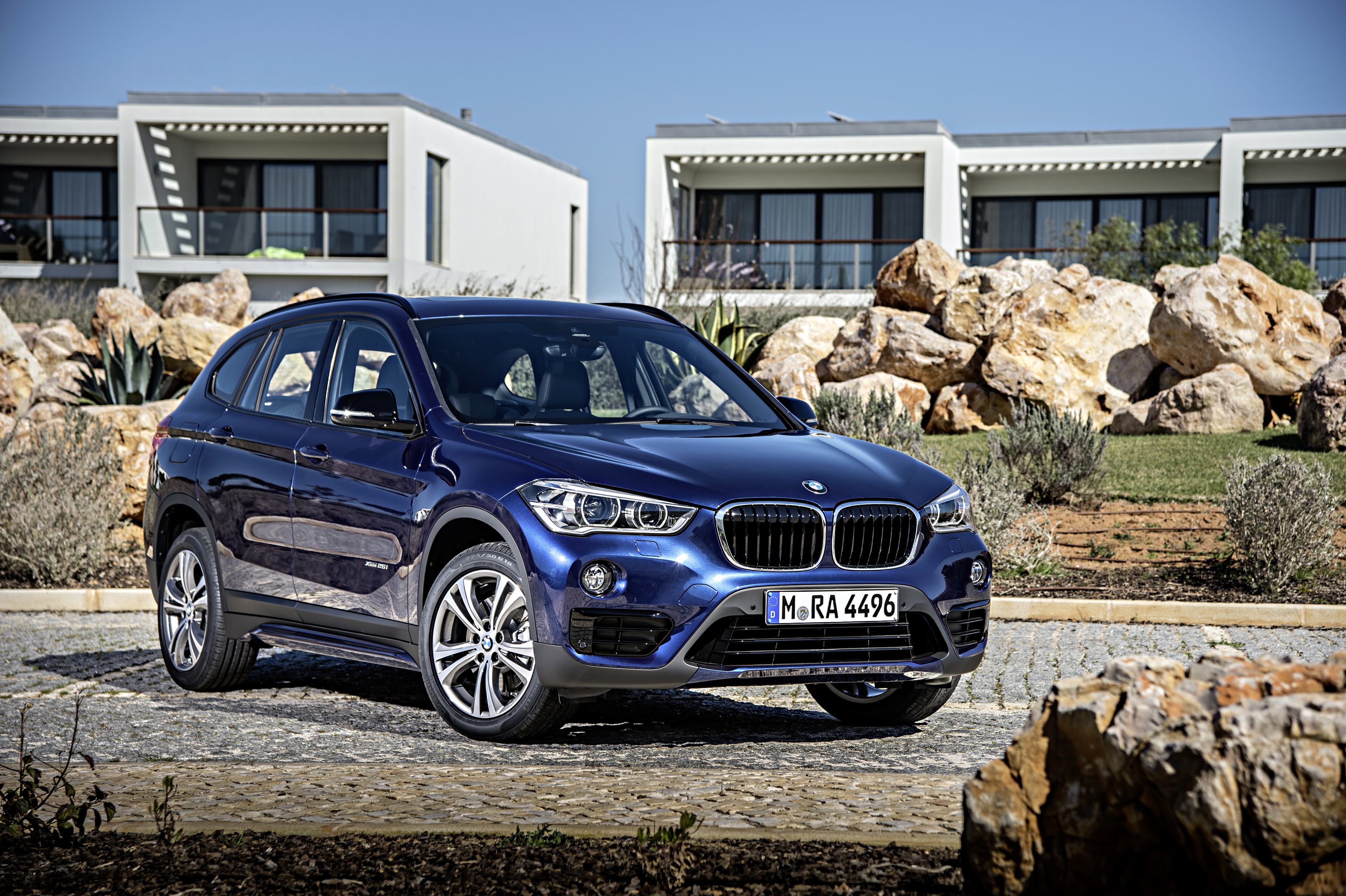 Blue 2015 BMW X1 xDrive25i parked near modern buildings HD Wallpaper