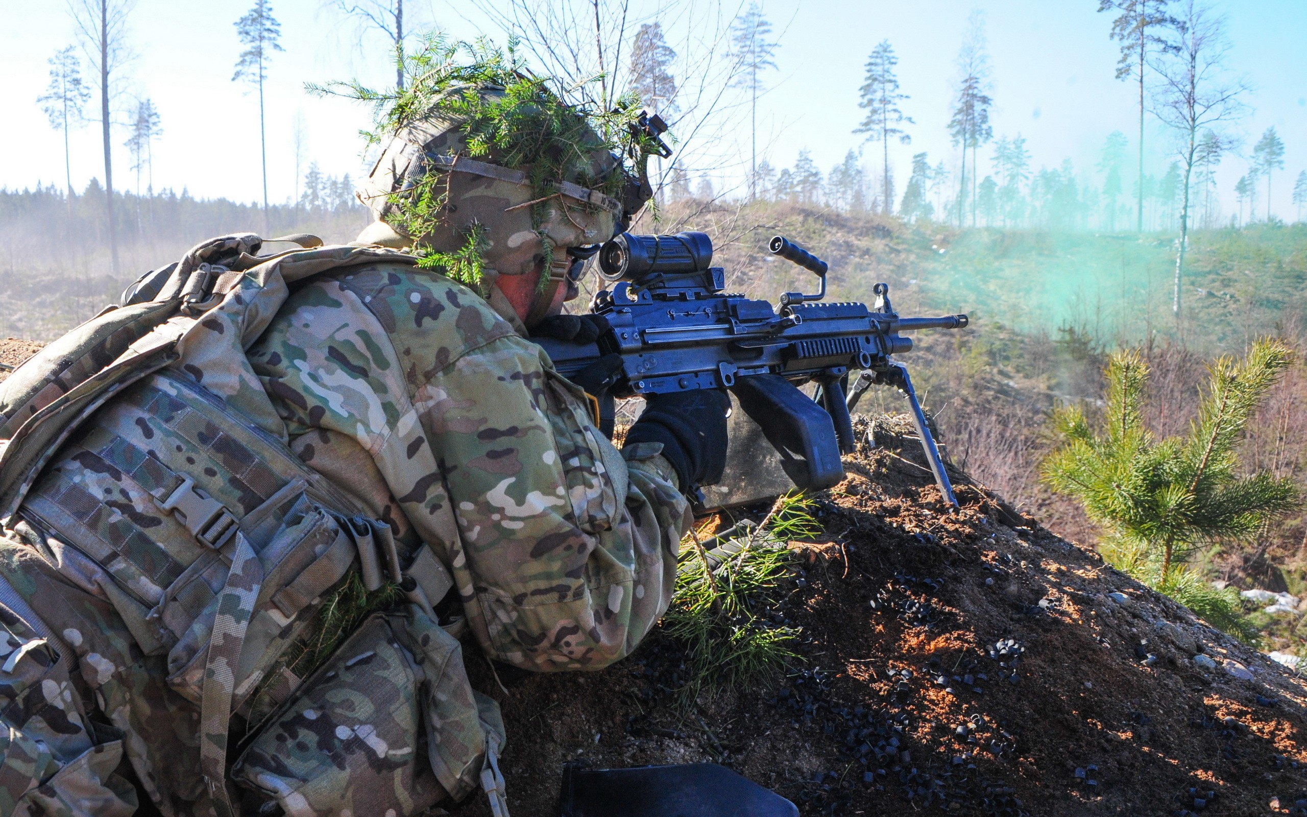 Soldier aiming a machine gun in a forest HD Wallpaper