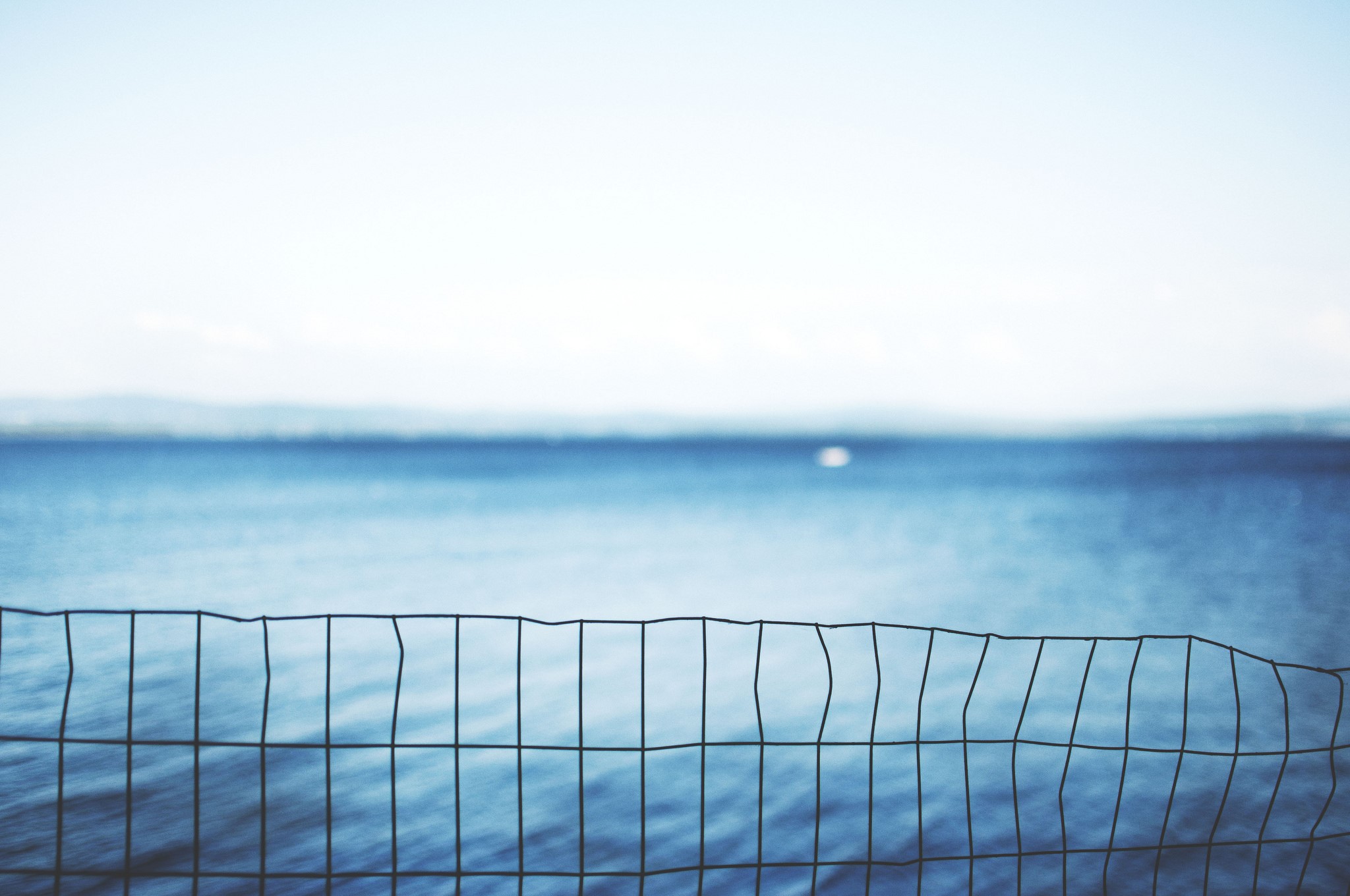Wire fence in front of the sea and sky HD Wallpaper