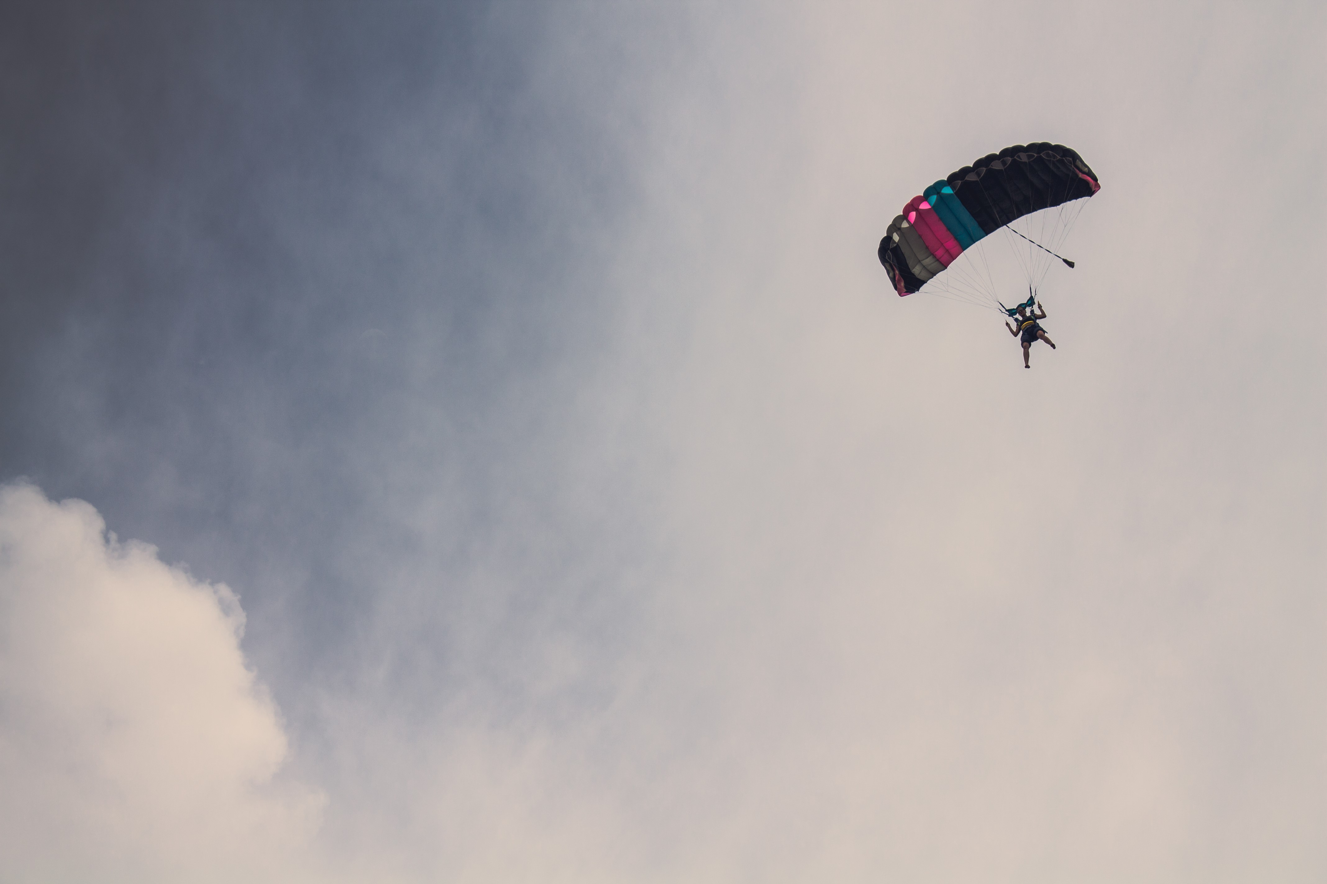Skydiver with colorful parachute against cloudy sky HD Wallpaper