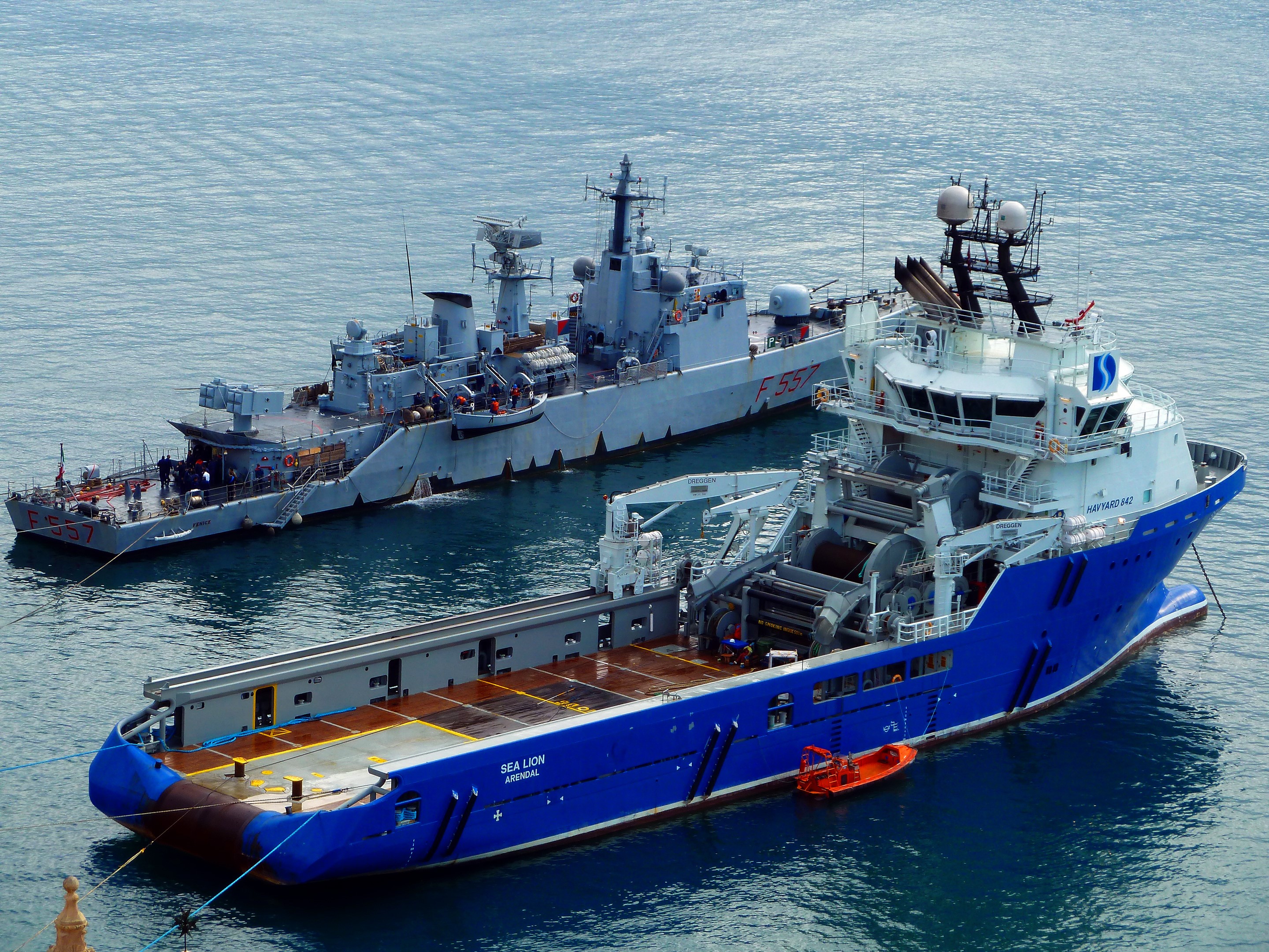 Two ships docked at sea, one blue and one gray HD Wallpaper