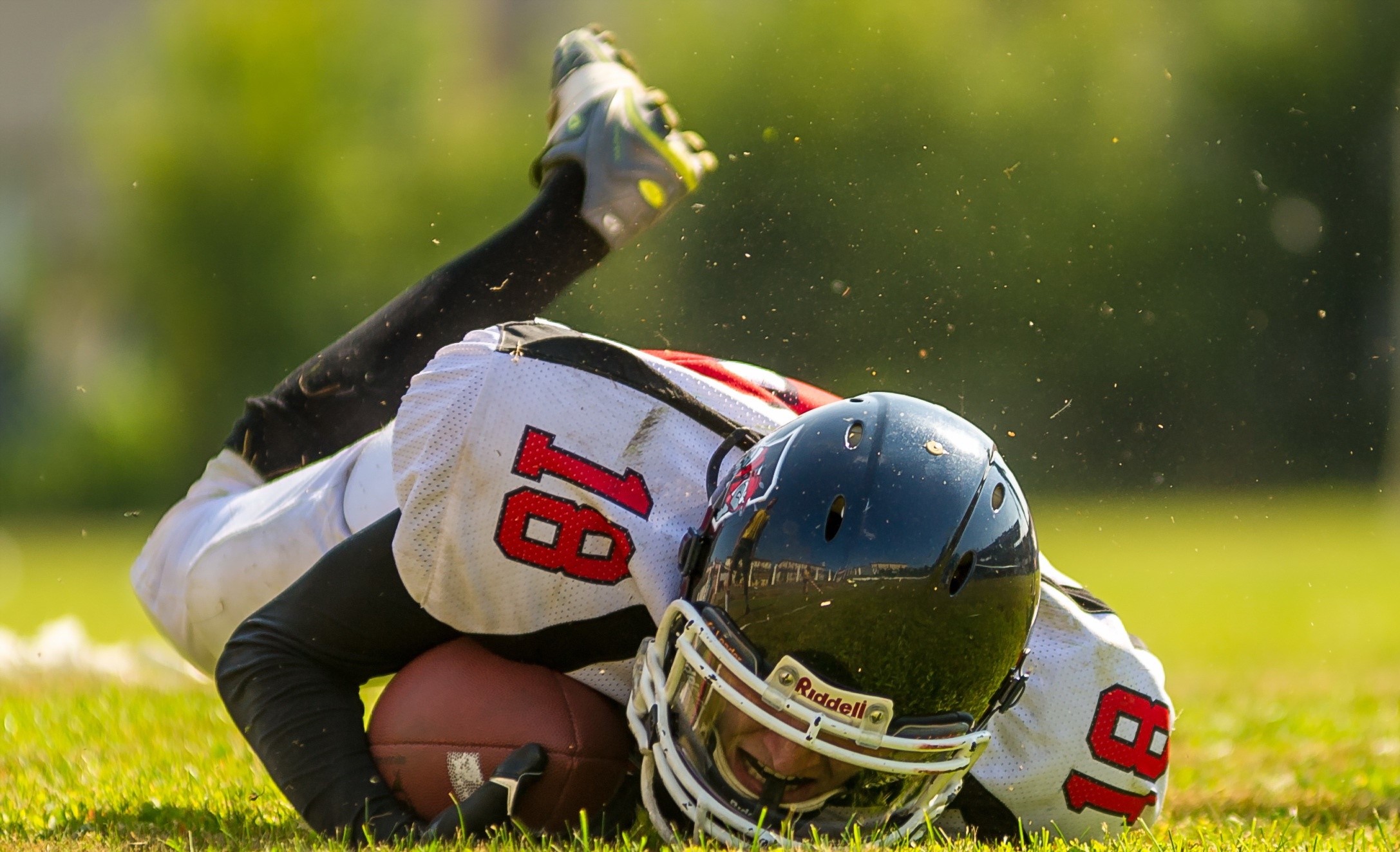 American football player with number 18 on the ground HD Wallpaper