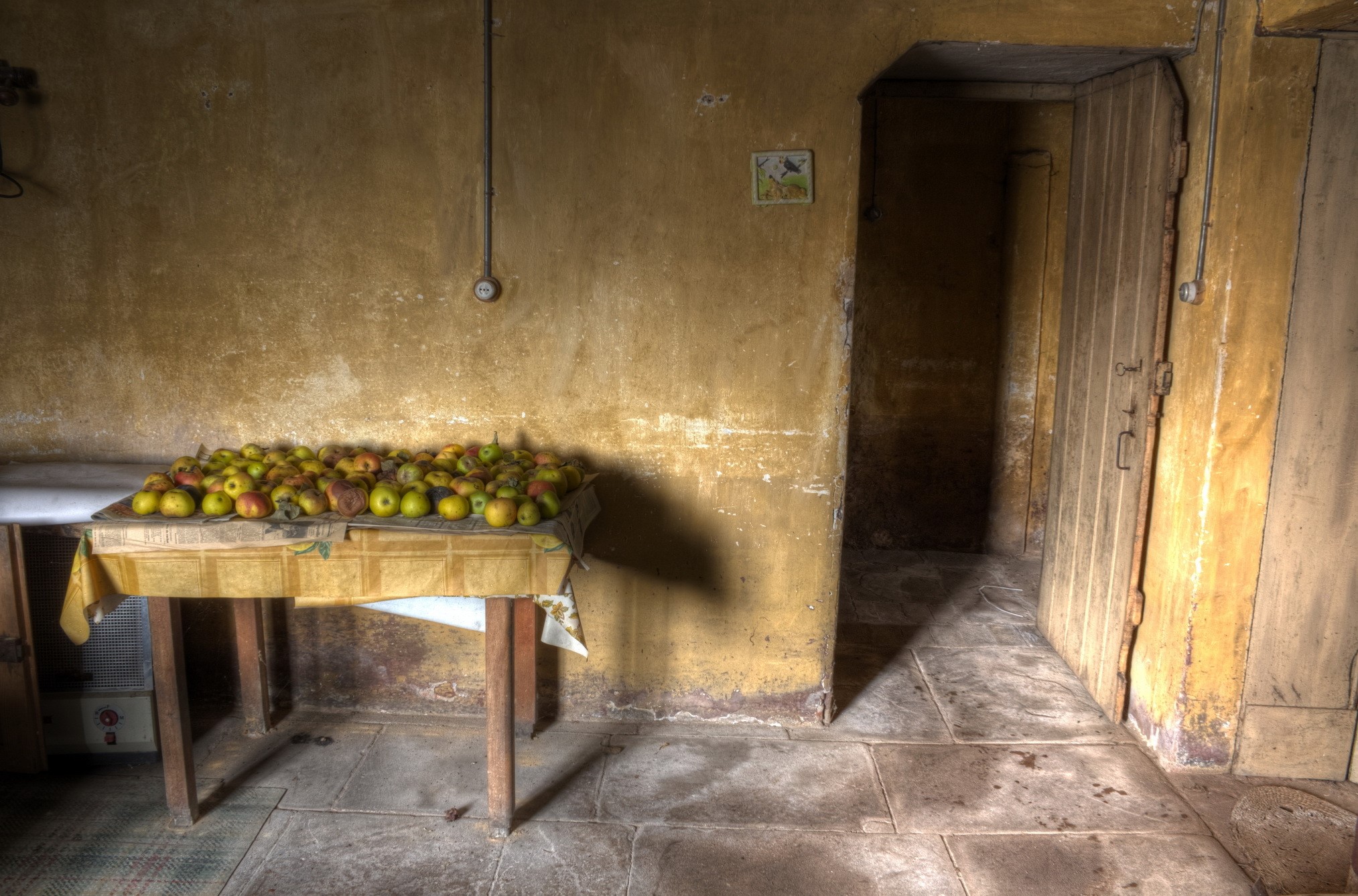Apples on a table in a rustic room with a door HD Wallpaper