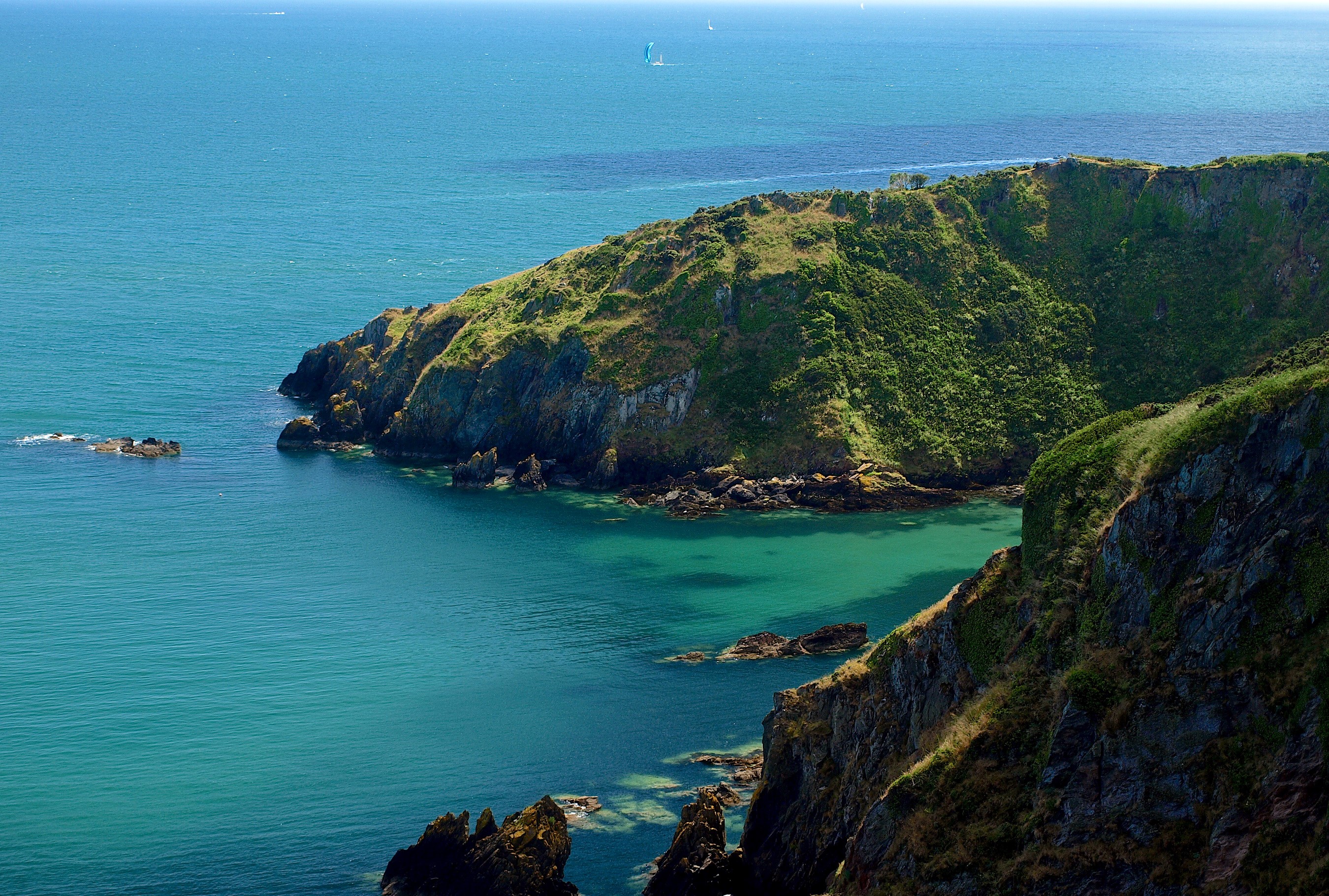Green cliffs overlooking a turquoise bay in Dartmouth, England HD Wallpaper