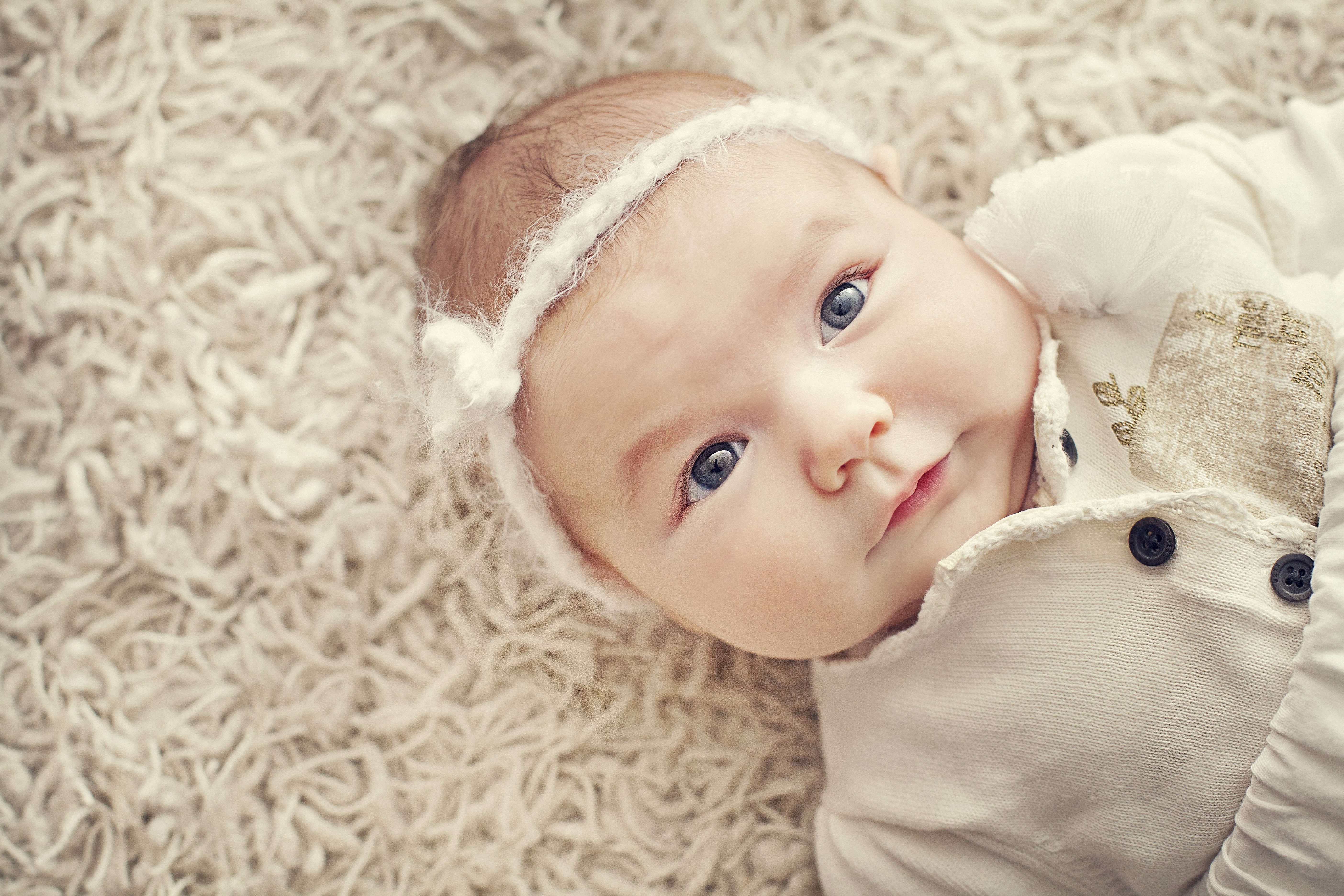 Infant with blue eyes wearing a white headband HD Wallpaper