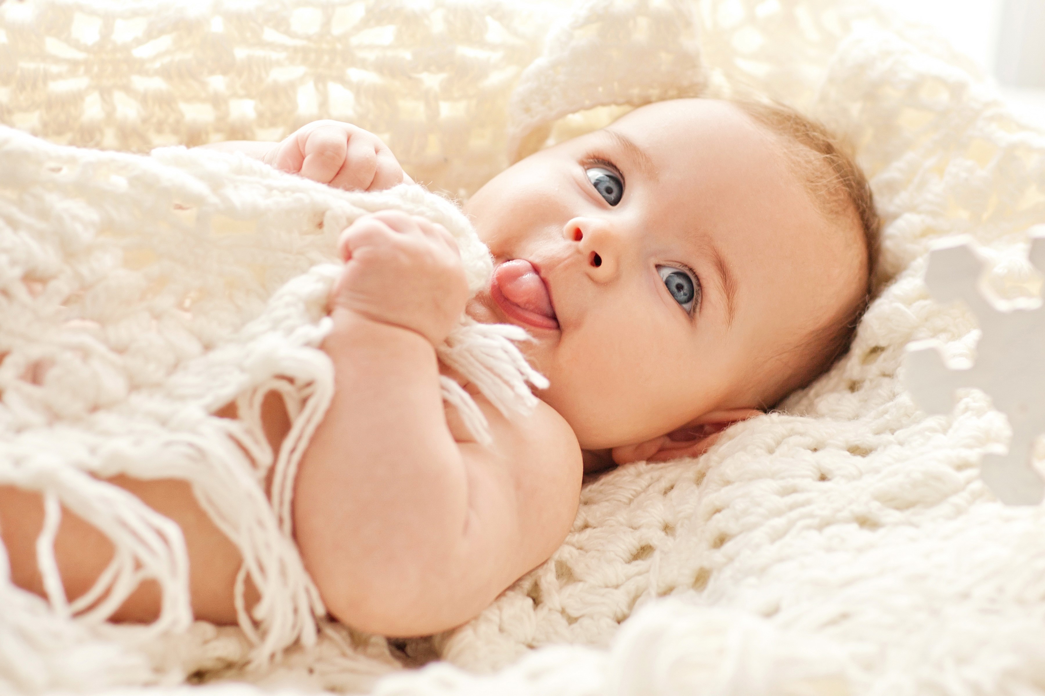 Baby with blue eyes sticking tongue out HD Wallpaper