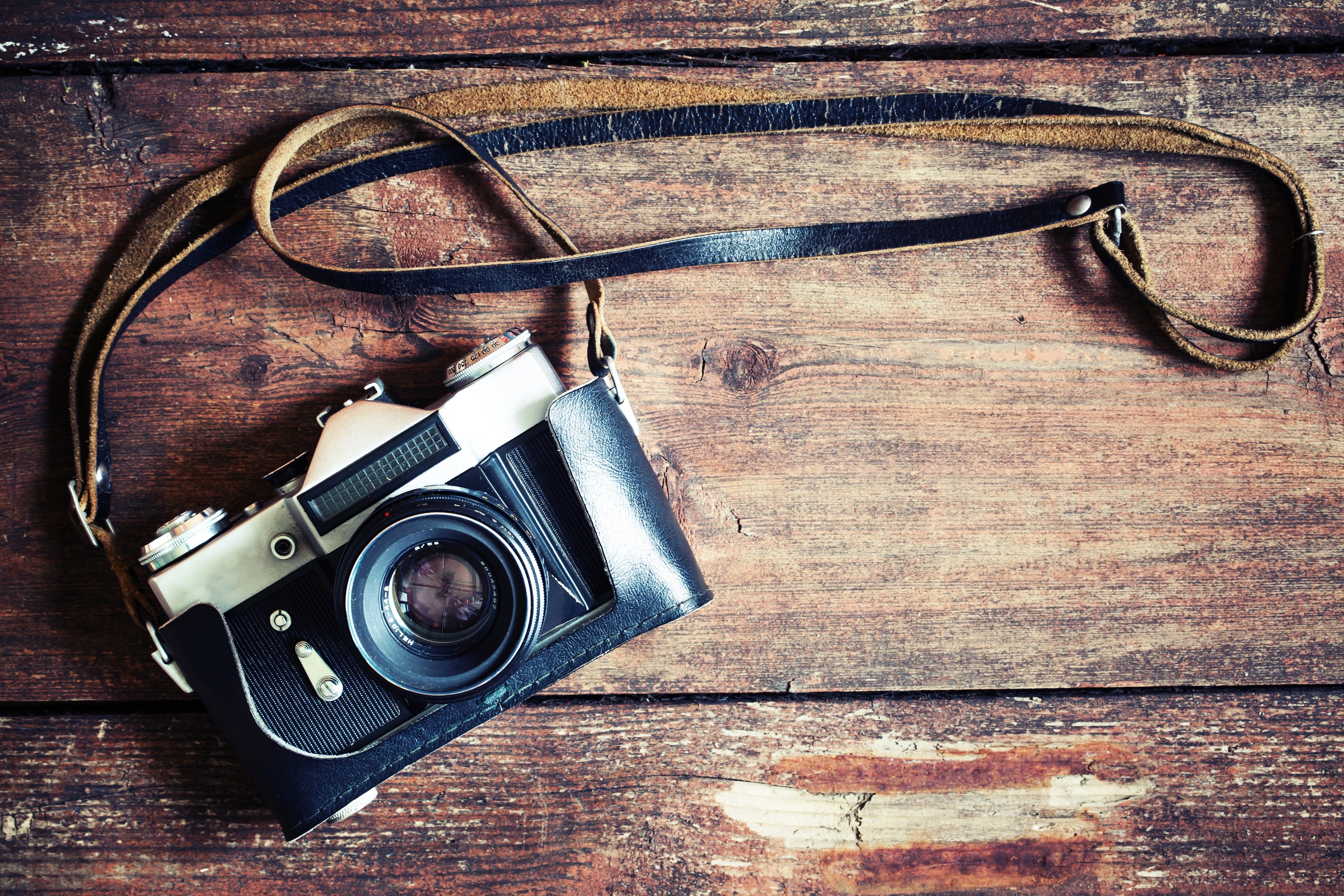 Vintage camera with leather strap on wooden background HD Wallpaper