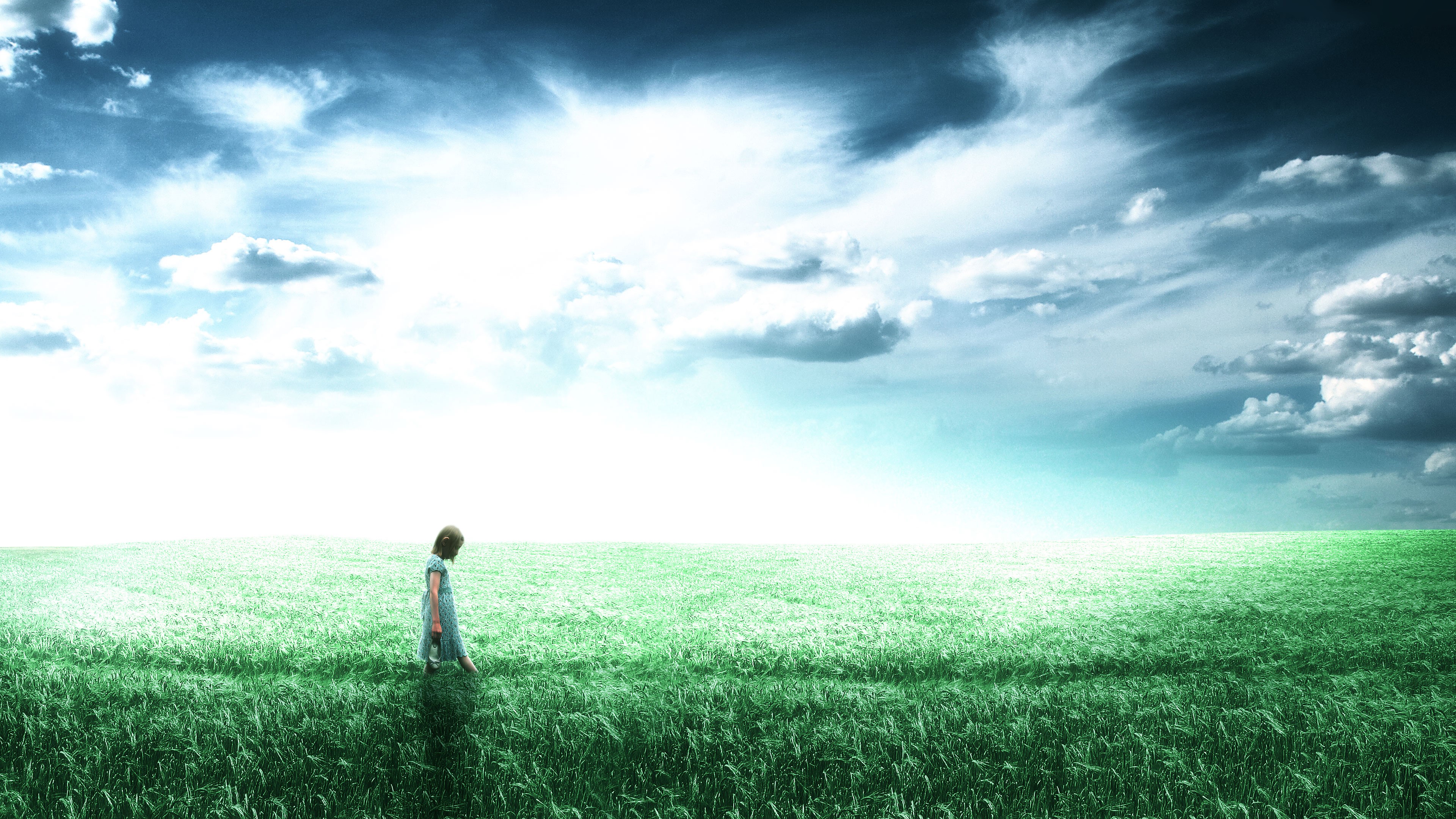Little girl in a field under a cloudy sky HD Wallpaper