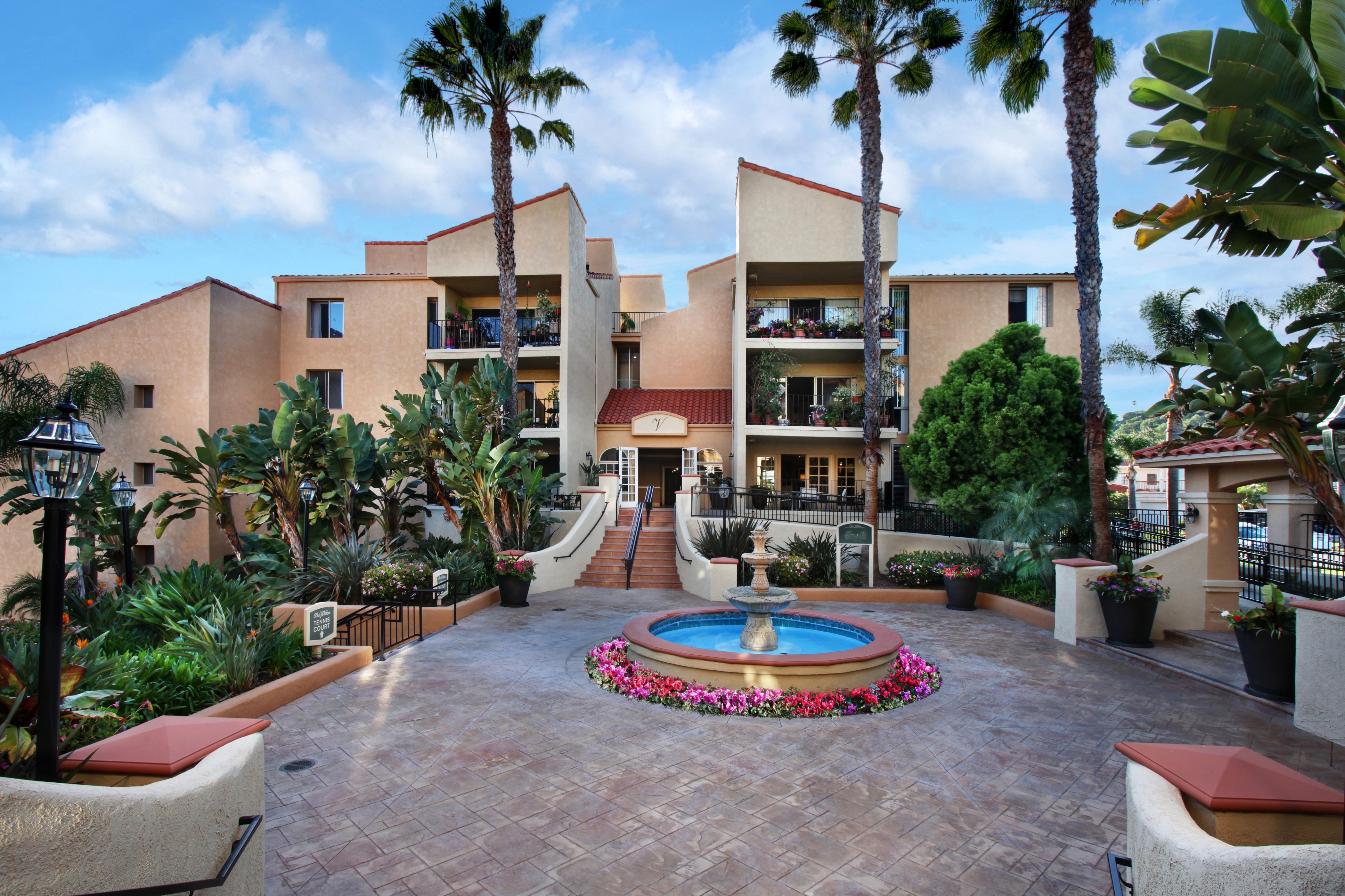 Apartment building with fountain and palm trees HD Wallpaper