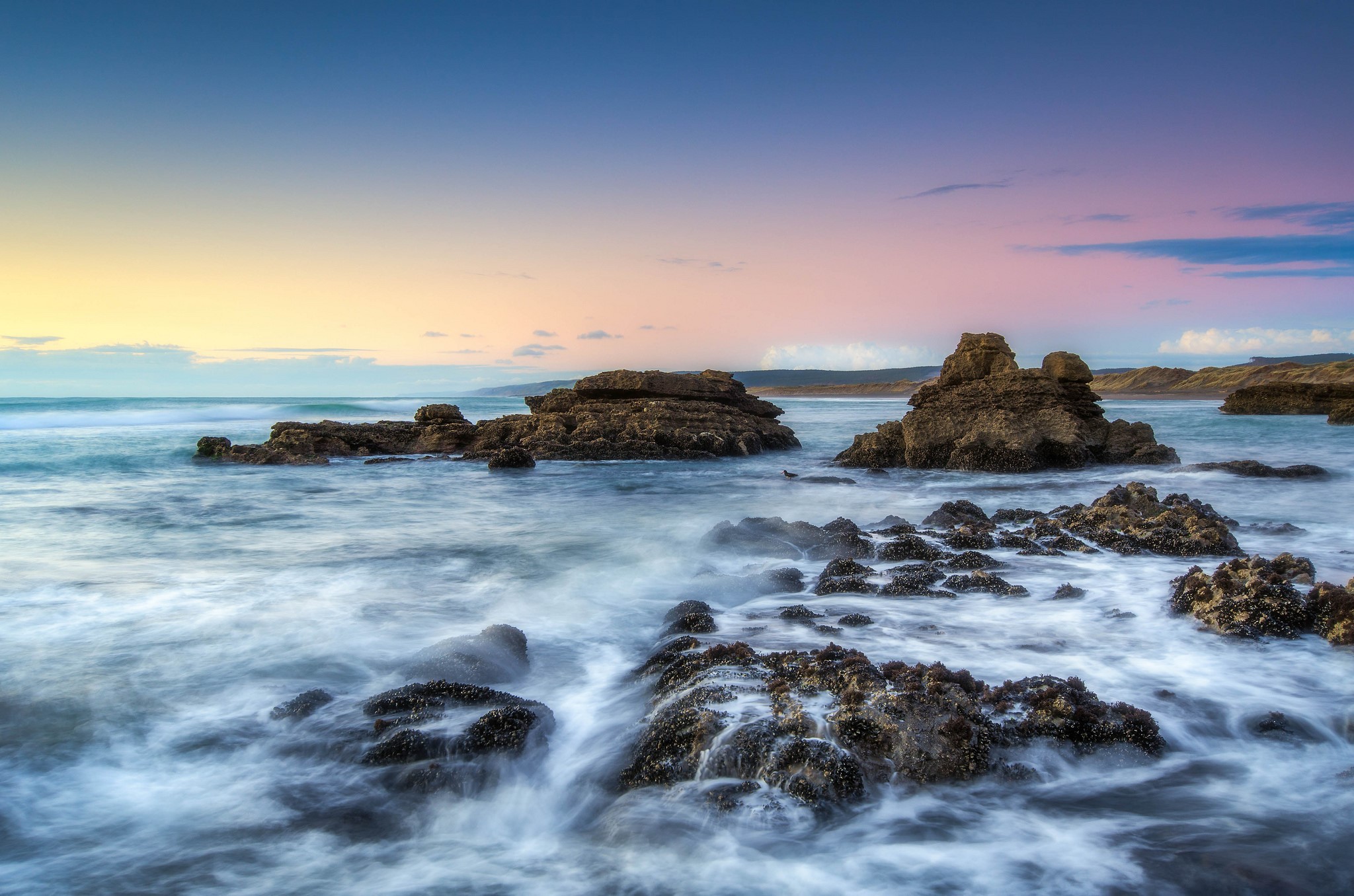 Ocean waves crashing on rocks at sunset HD Wallpaper