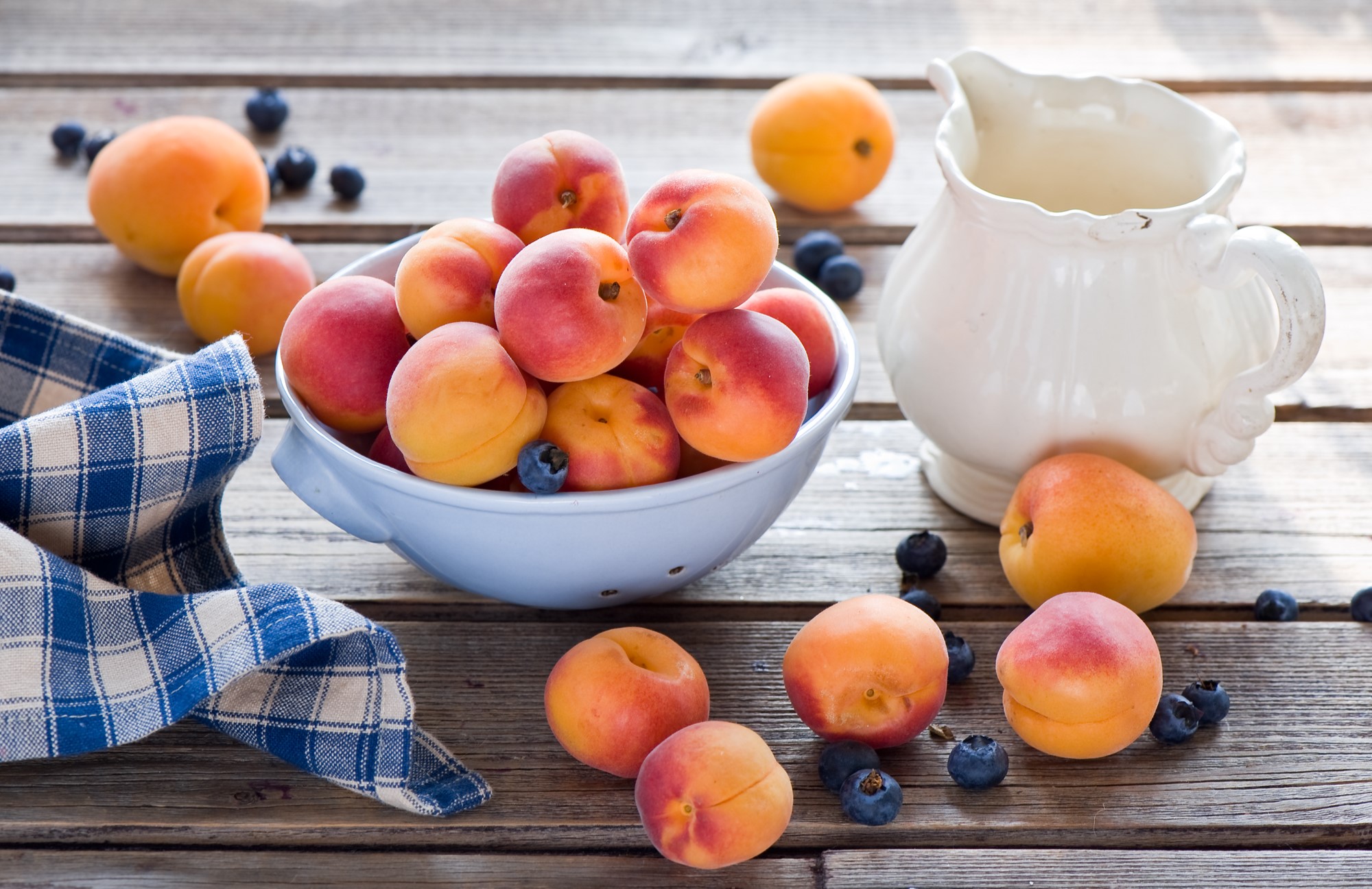 Apricots and blueberries in a bowl with a pitcher HD Wallpaper