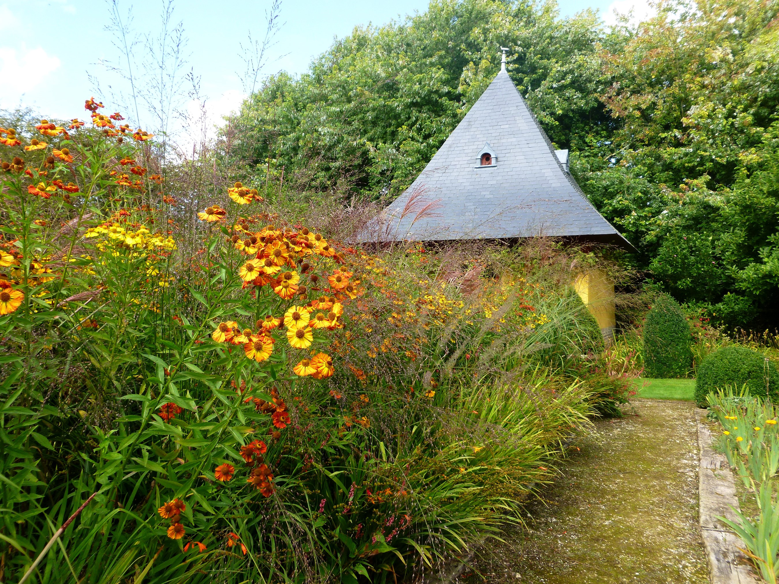 Garden with flowers and a small building HD Wallpaper