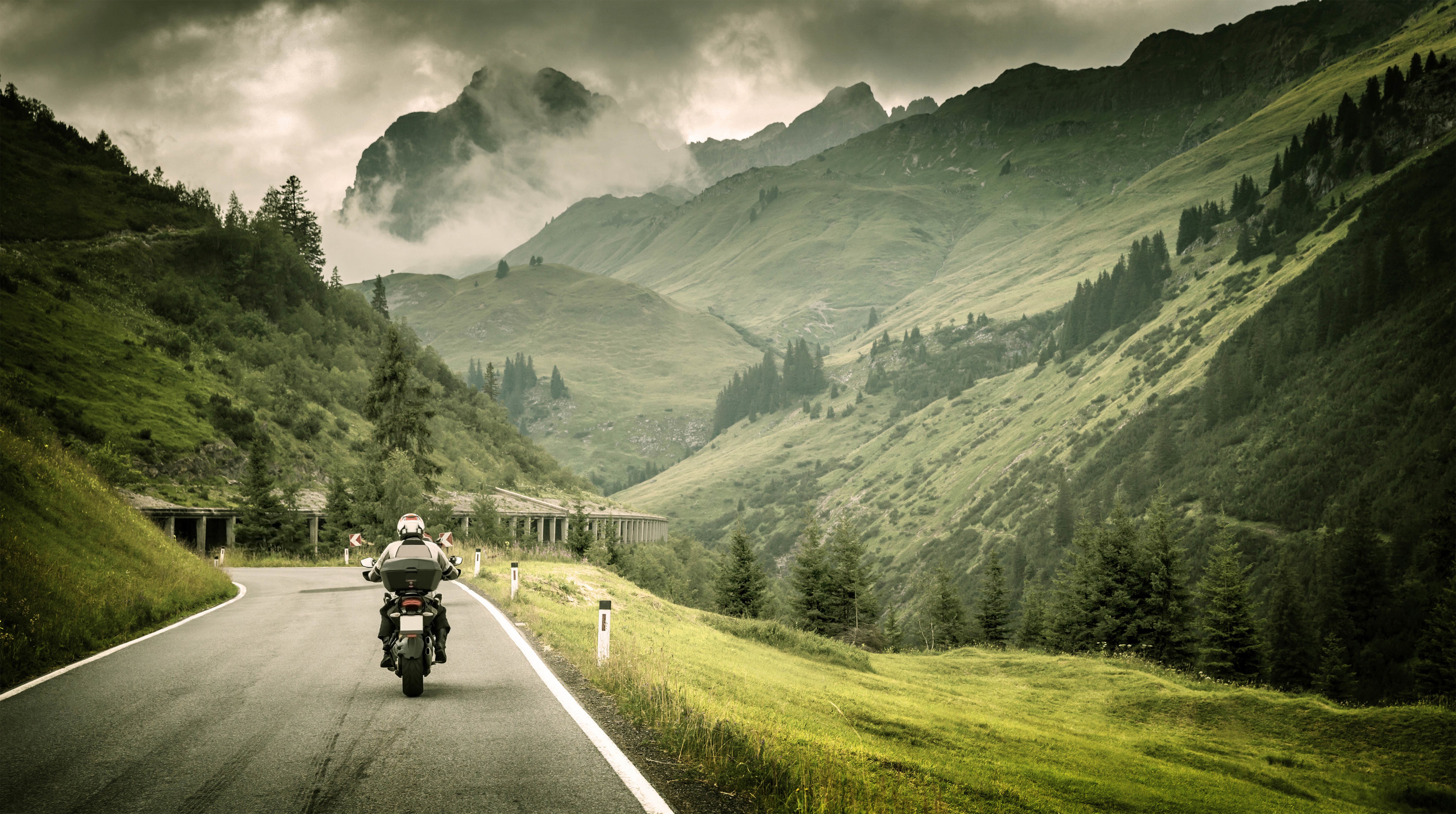 Motorcyclist on a mountain road HD Wallpaper