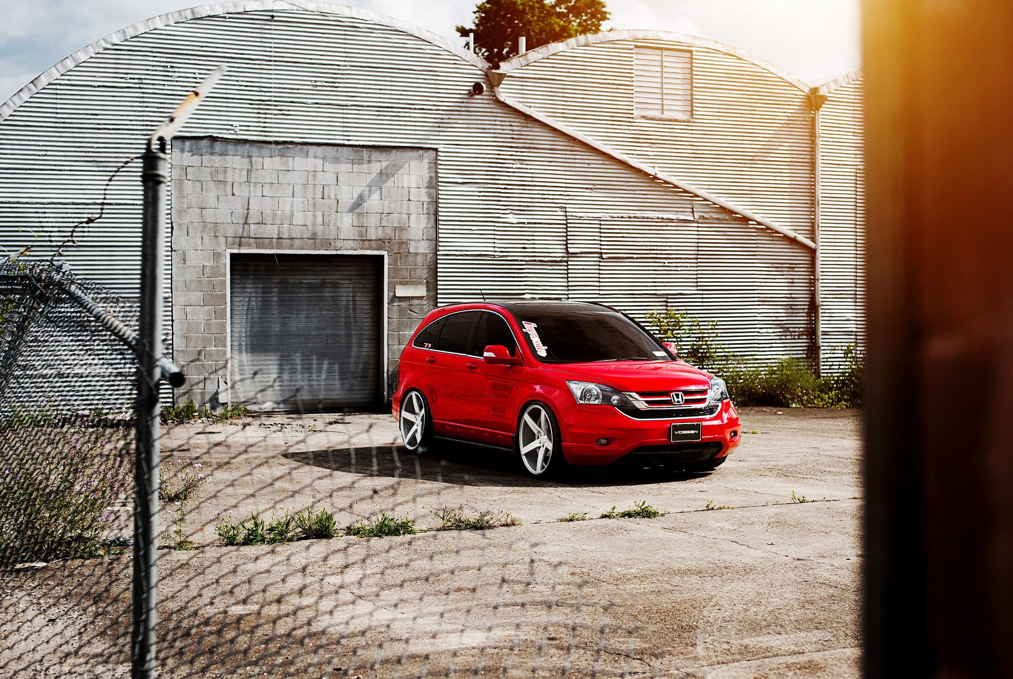 Red Honda CR-V parked outside a corrugated metal building HD Wallpaper