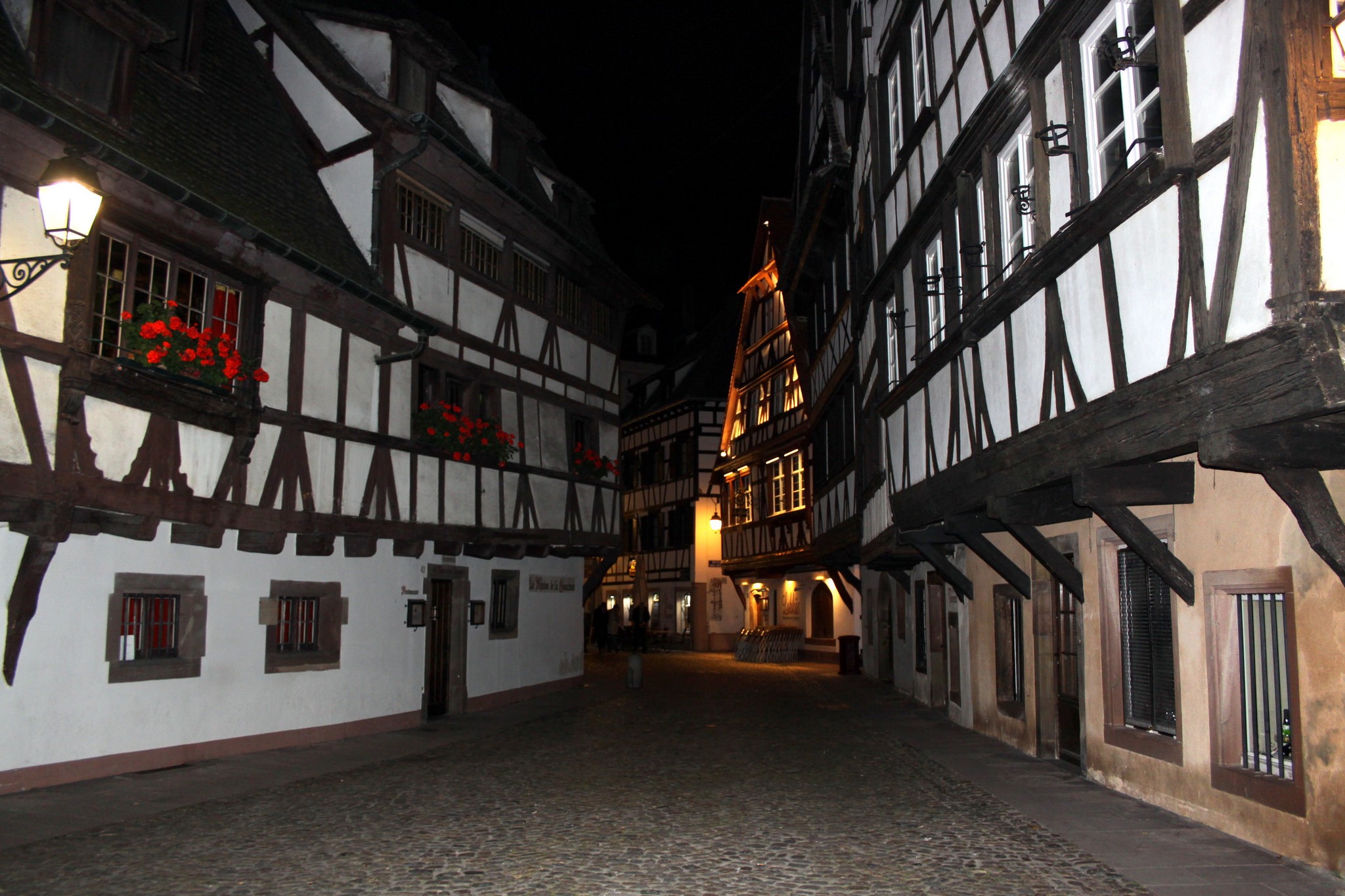 Timber-framed houses on a cobblestone street at night in Strasbourg, France HD Wallpaper