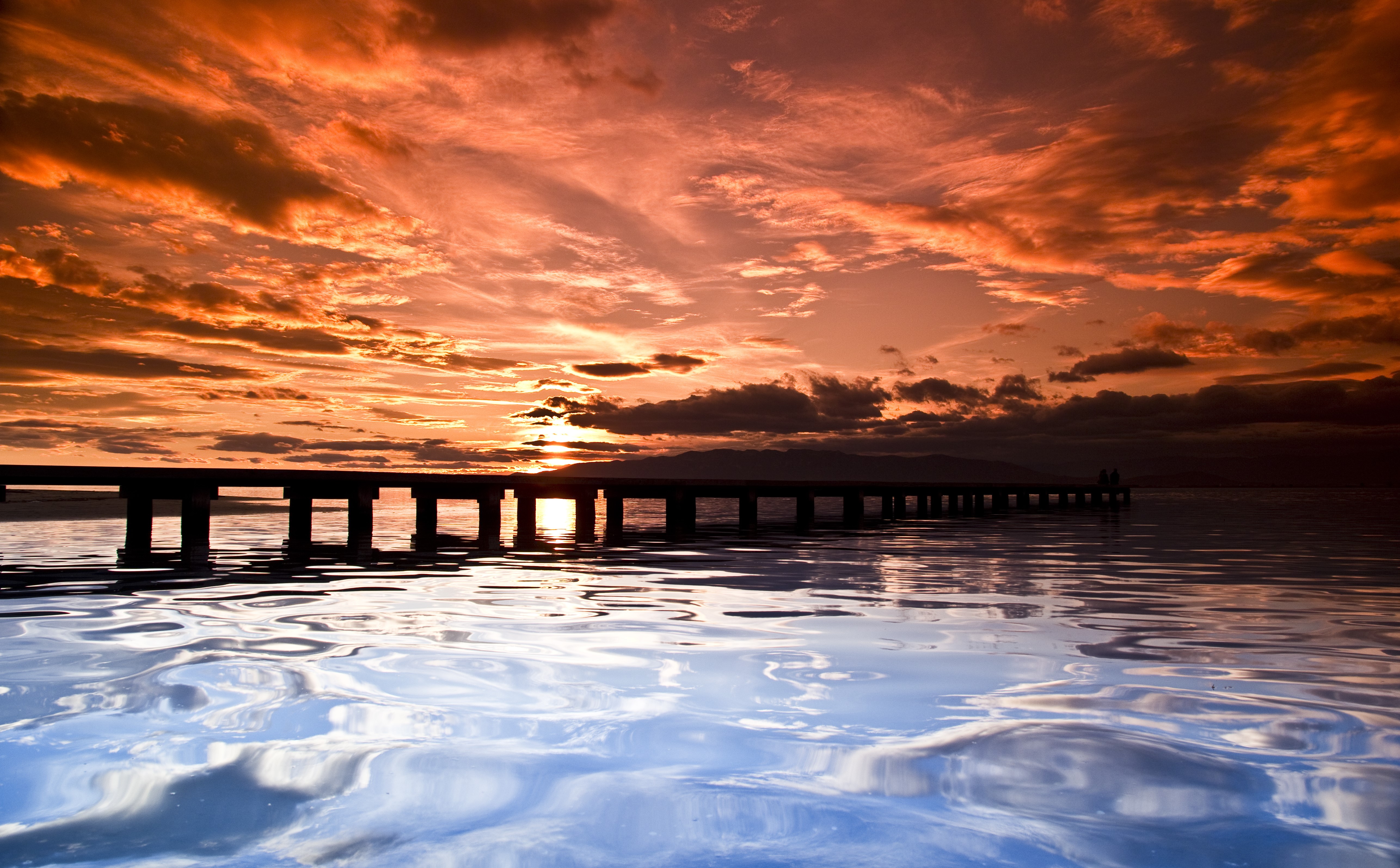 Sunset over a pier with dramatic clouds HD Wallpaper
