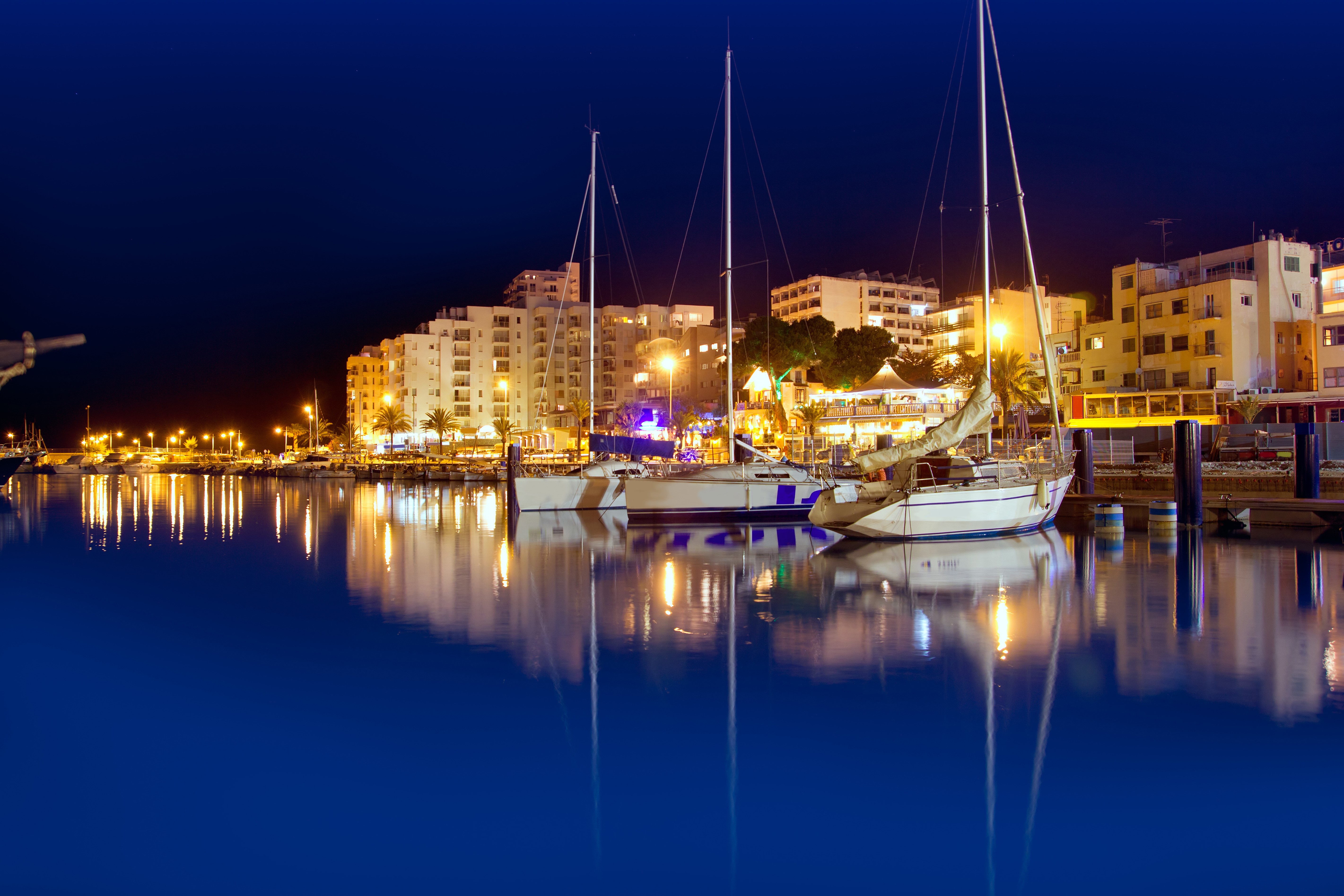 Night view of a marina with yachts and buildings HD Wallpaper