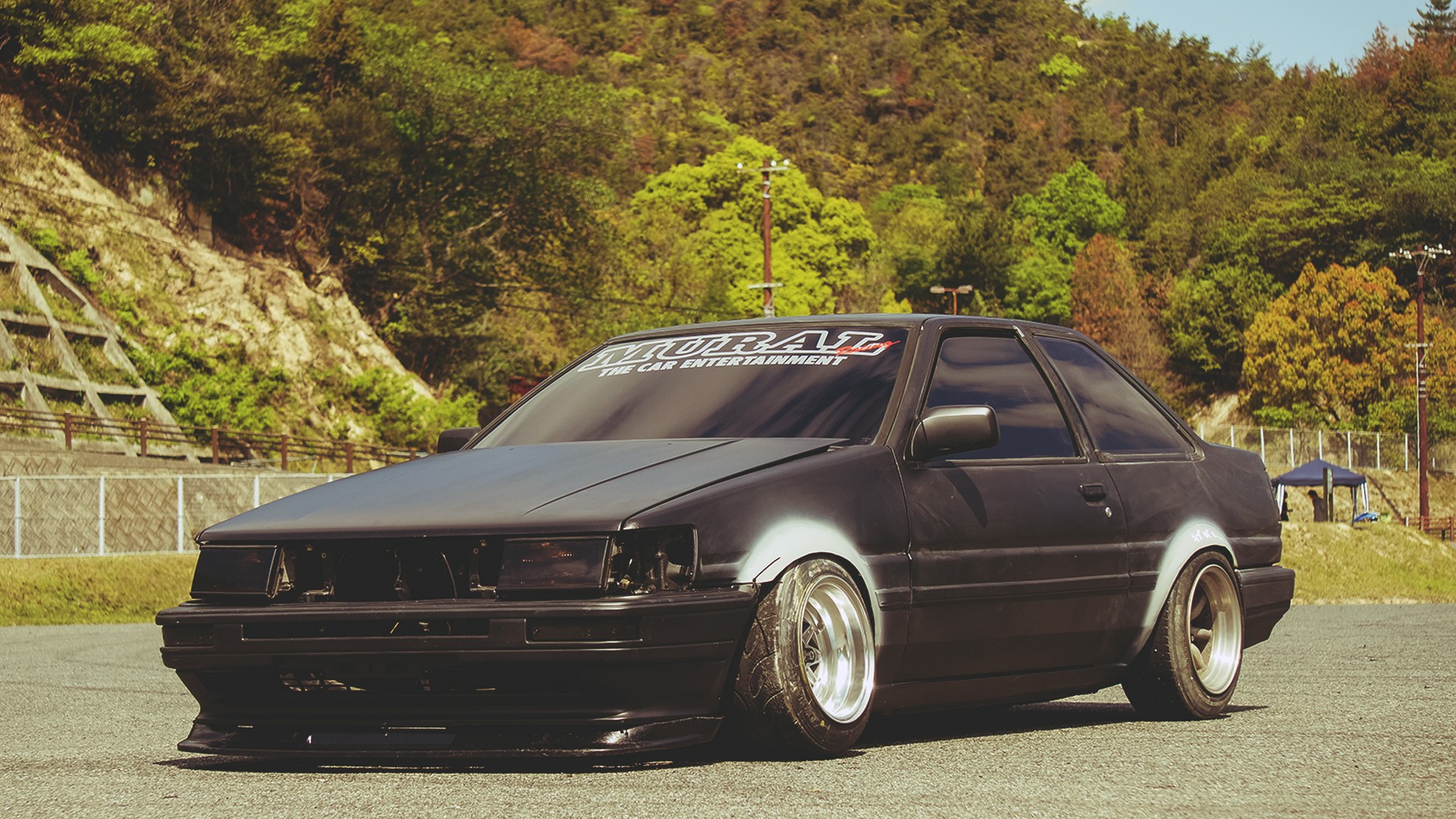 Black Toyota Corolla with "MURAI THE CAR ENTERTAINMENT" banner HD Wallpaper