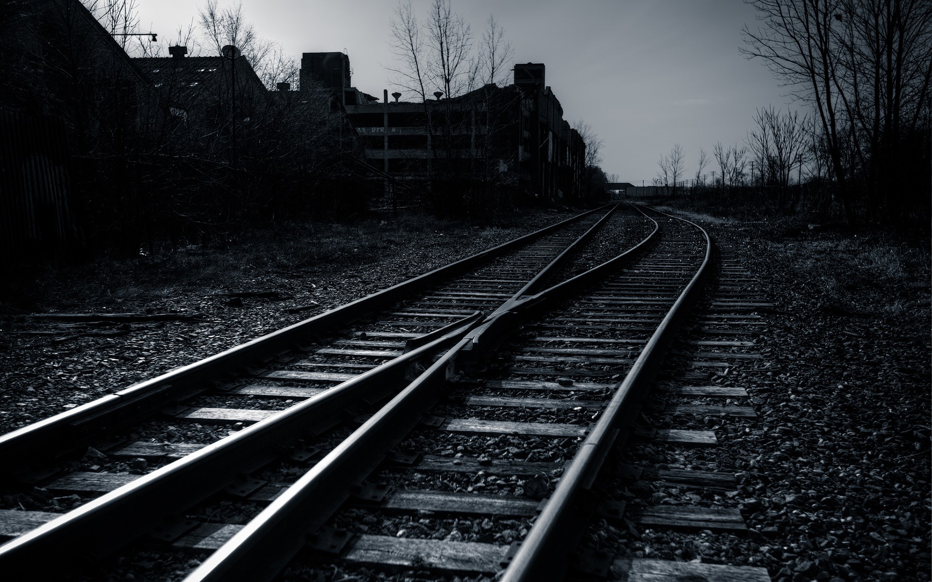 Abandoned railroad tracks leading to industrial buildings HD Wallpaper
