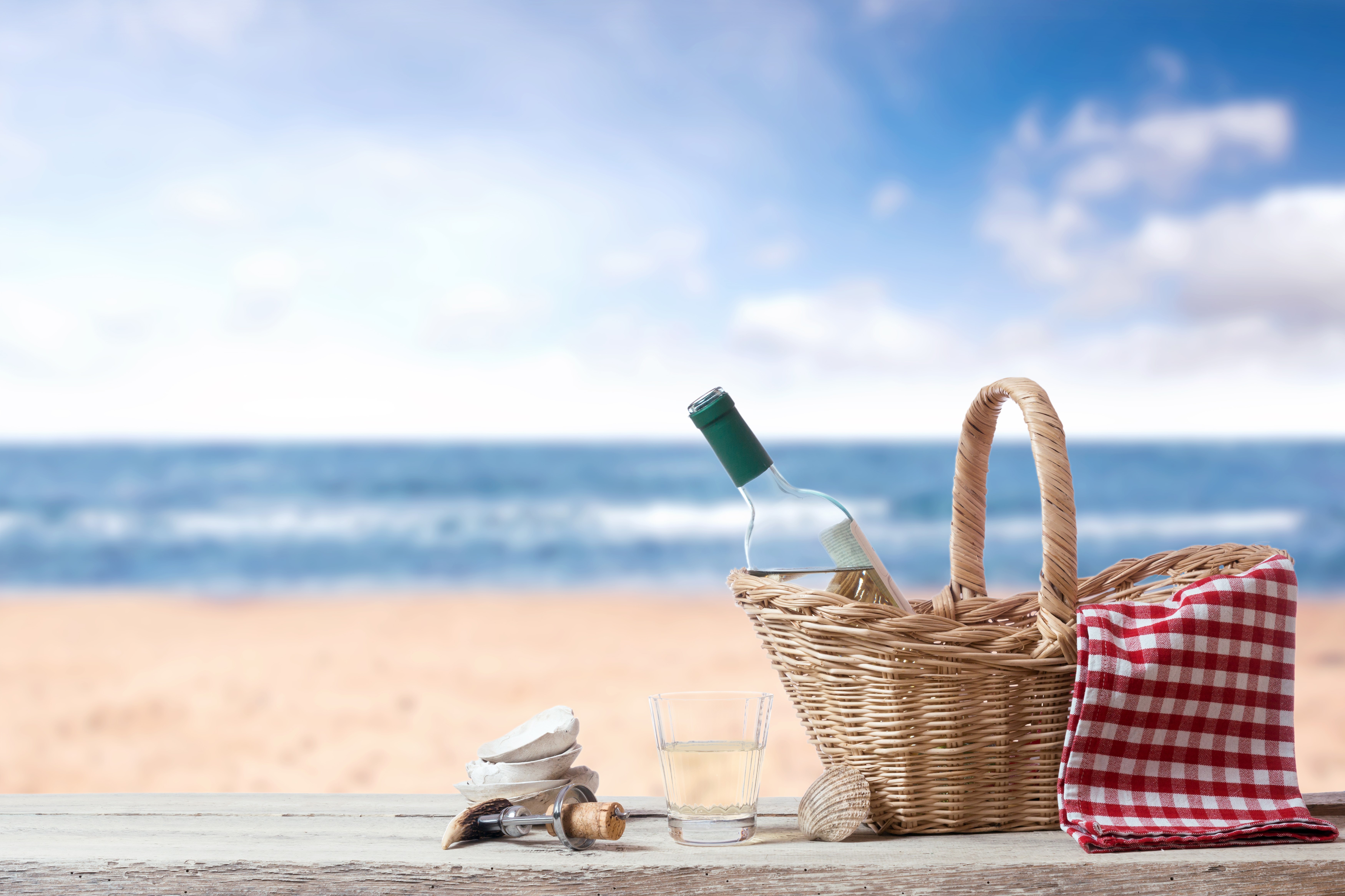 Picnic basket with wine bottle on a beach HD Wallpaper