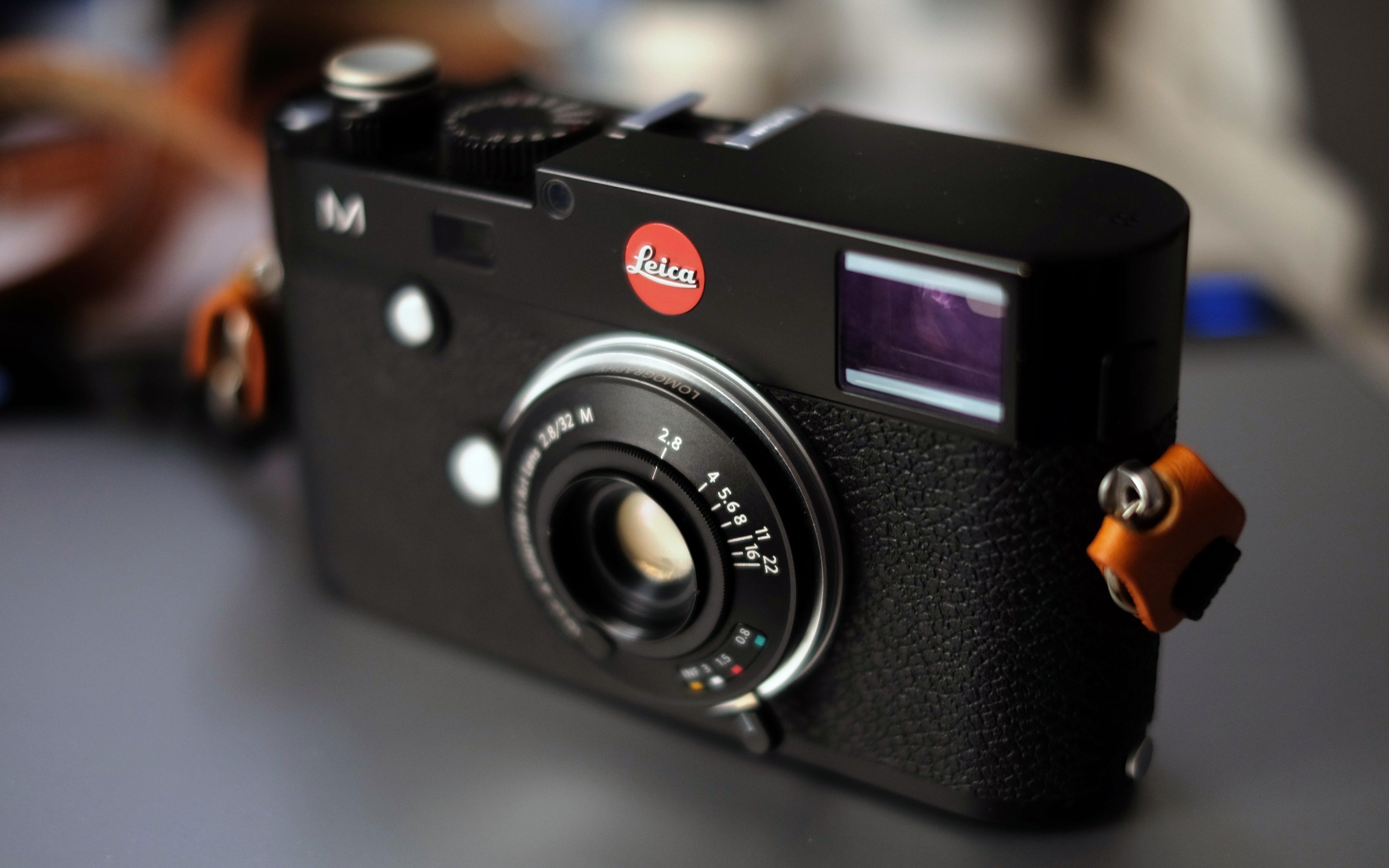 Black Leica M camera with orange strap lug HD Wallpaper