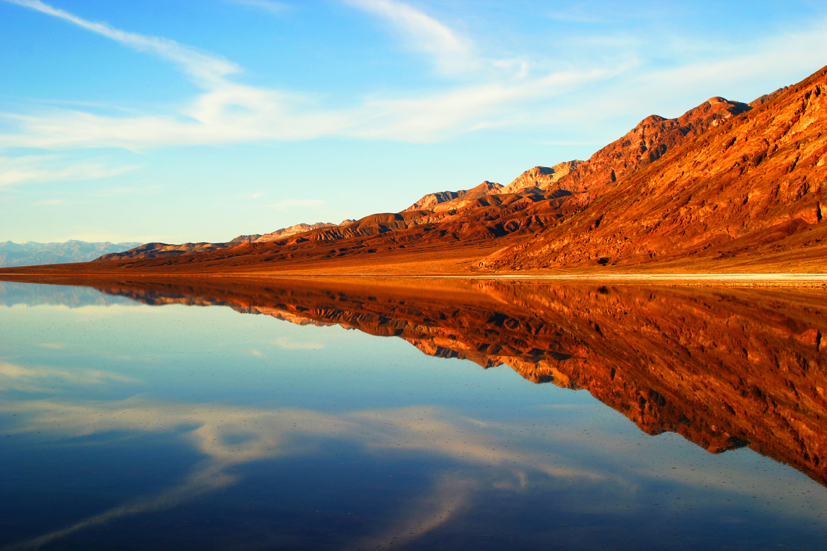 Mountains reflected in a calm lake at sunset HD Wallpaper