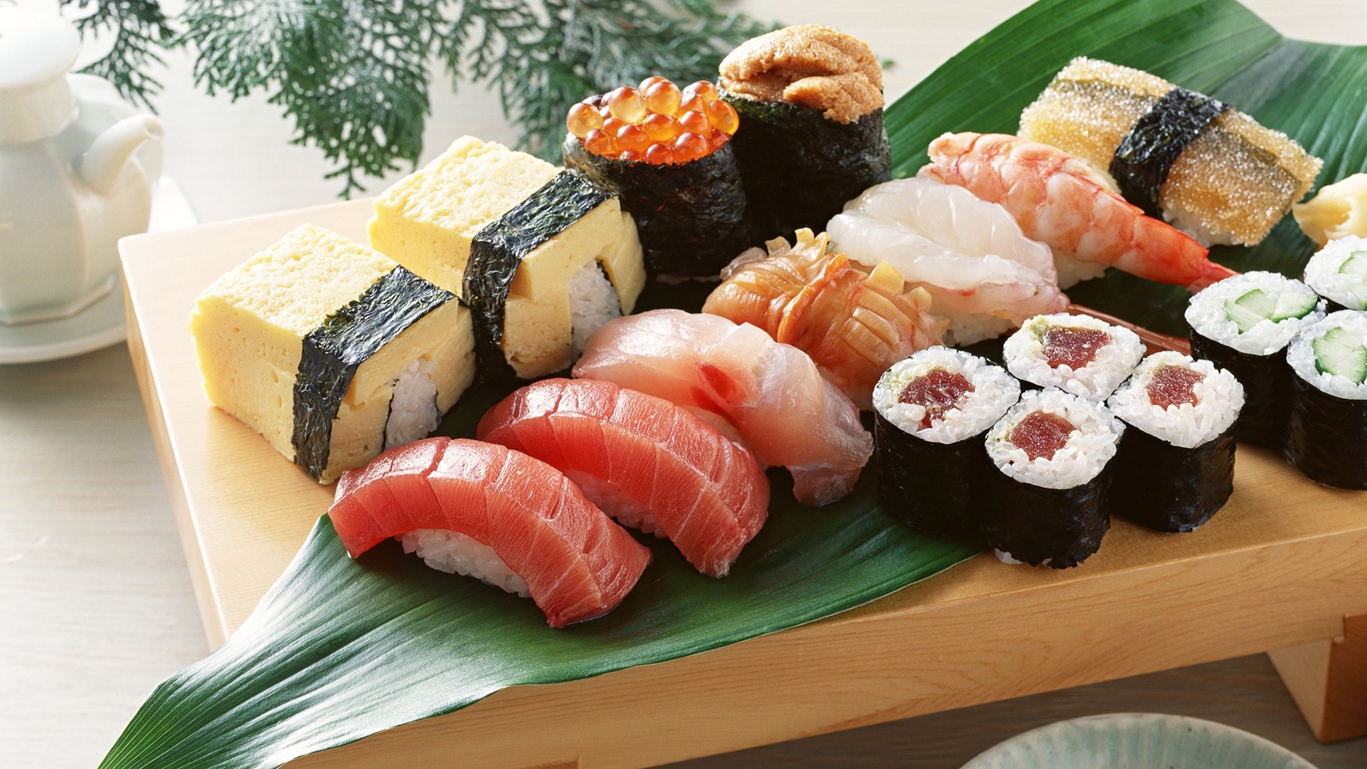 Assortment of fresh sushi on a wooden platter HD Wallpaper