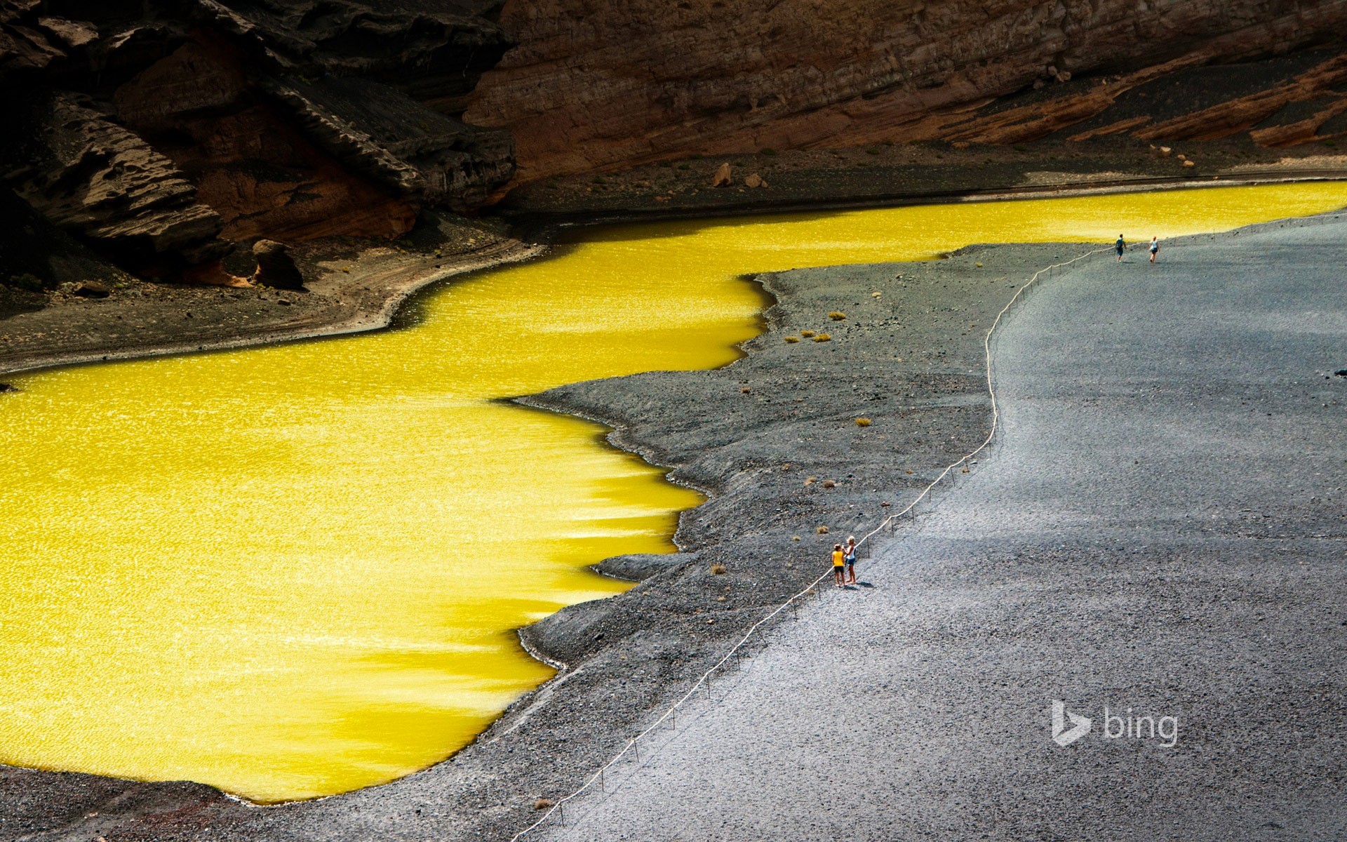 Yellow lake and rocky landscape with people HD Wallpaper