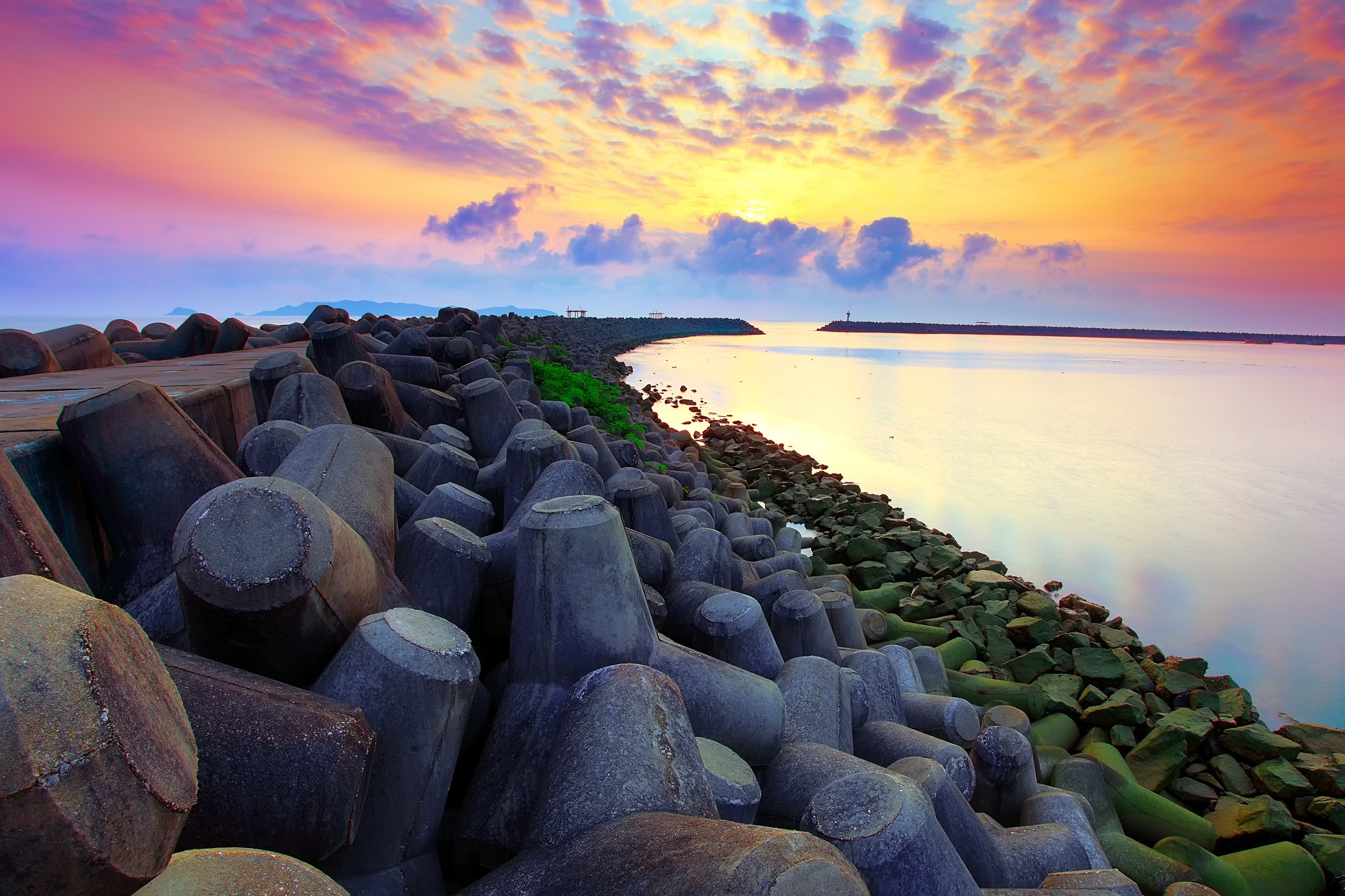 Tetrapods and breakwater at sunset over the sea HD Wallpaper
