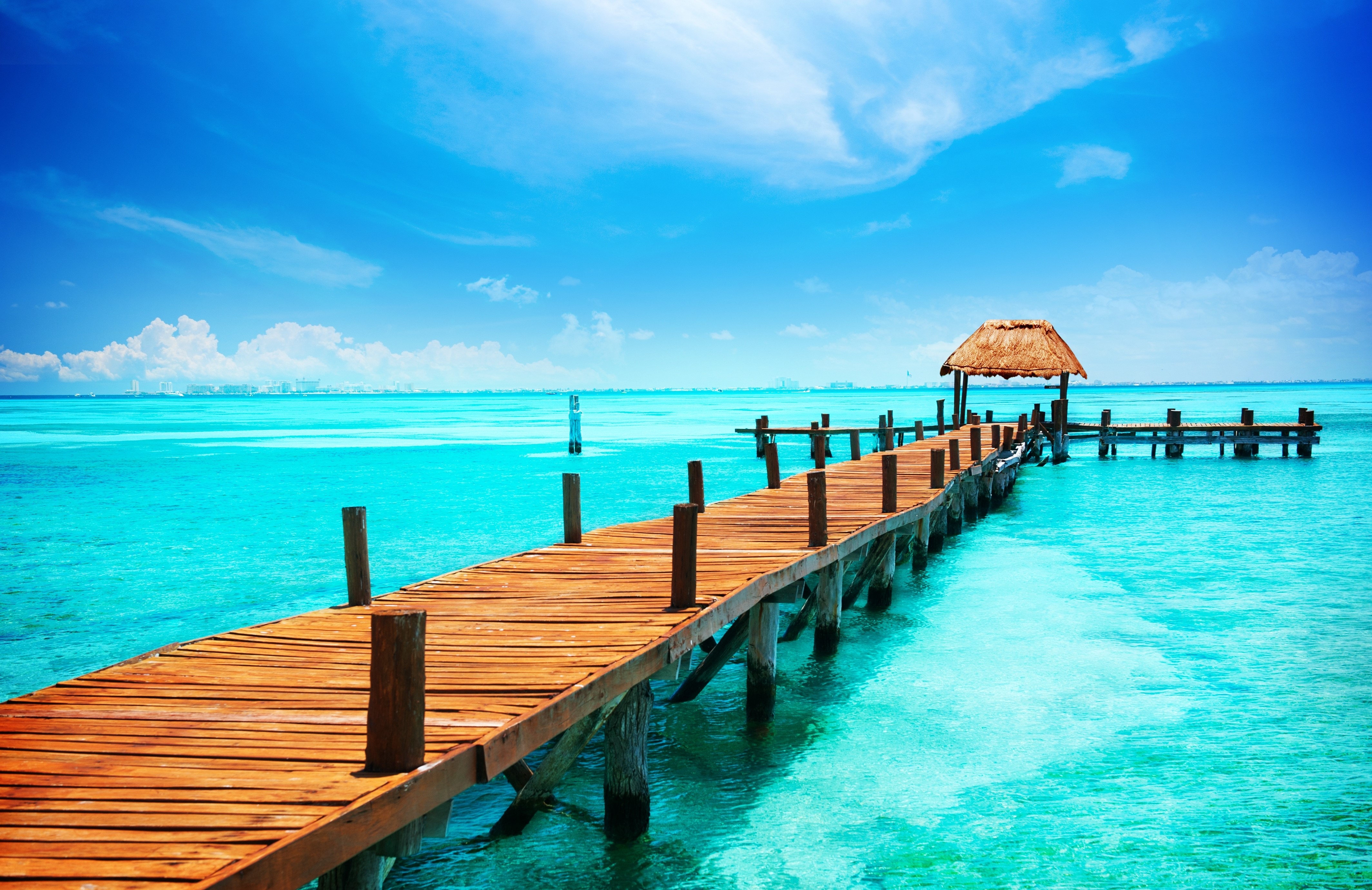Wooden pier on a turquoise sea under a blue sky HD Wallpaper