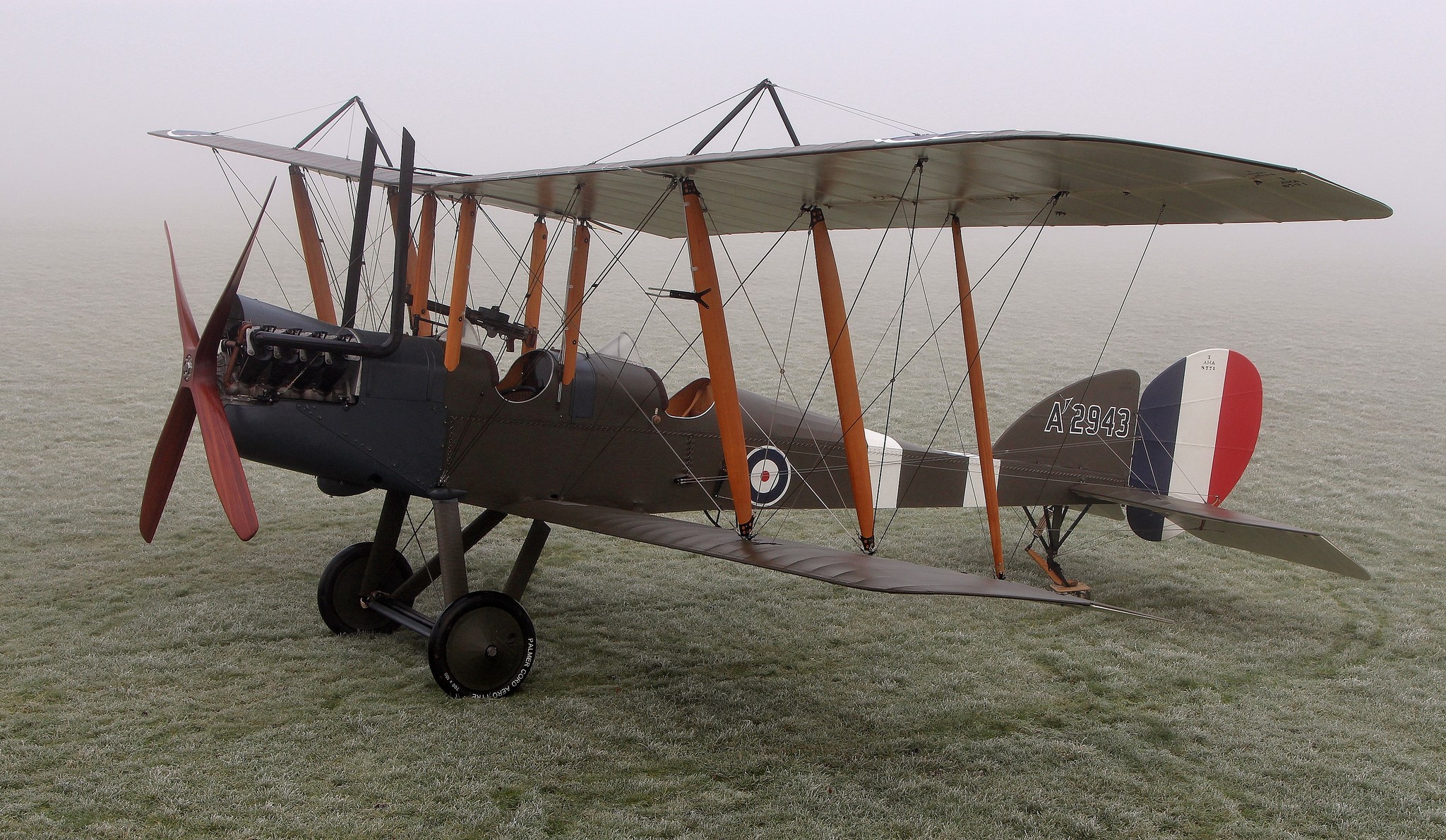Brown biplane with red propeller in fog HD Wallpaper