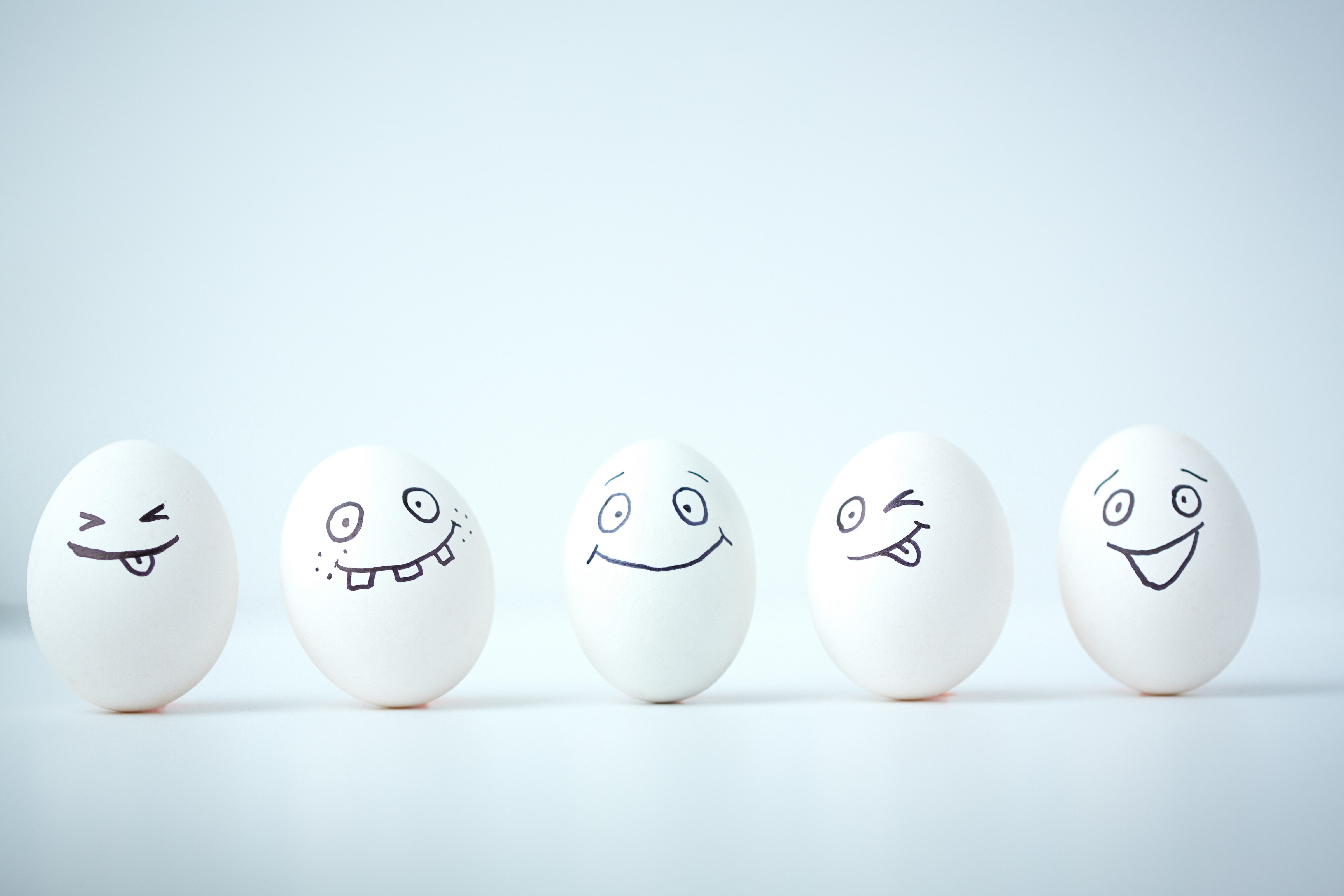 Five Easter eggs with drawn faces in a row HD Wallpaper
