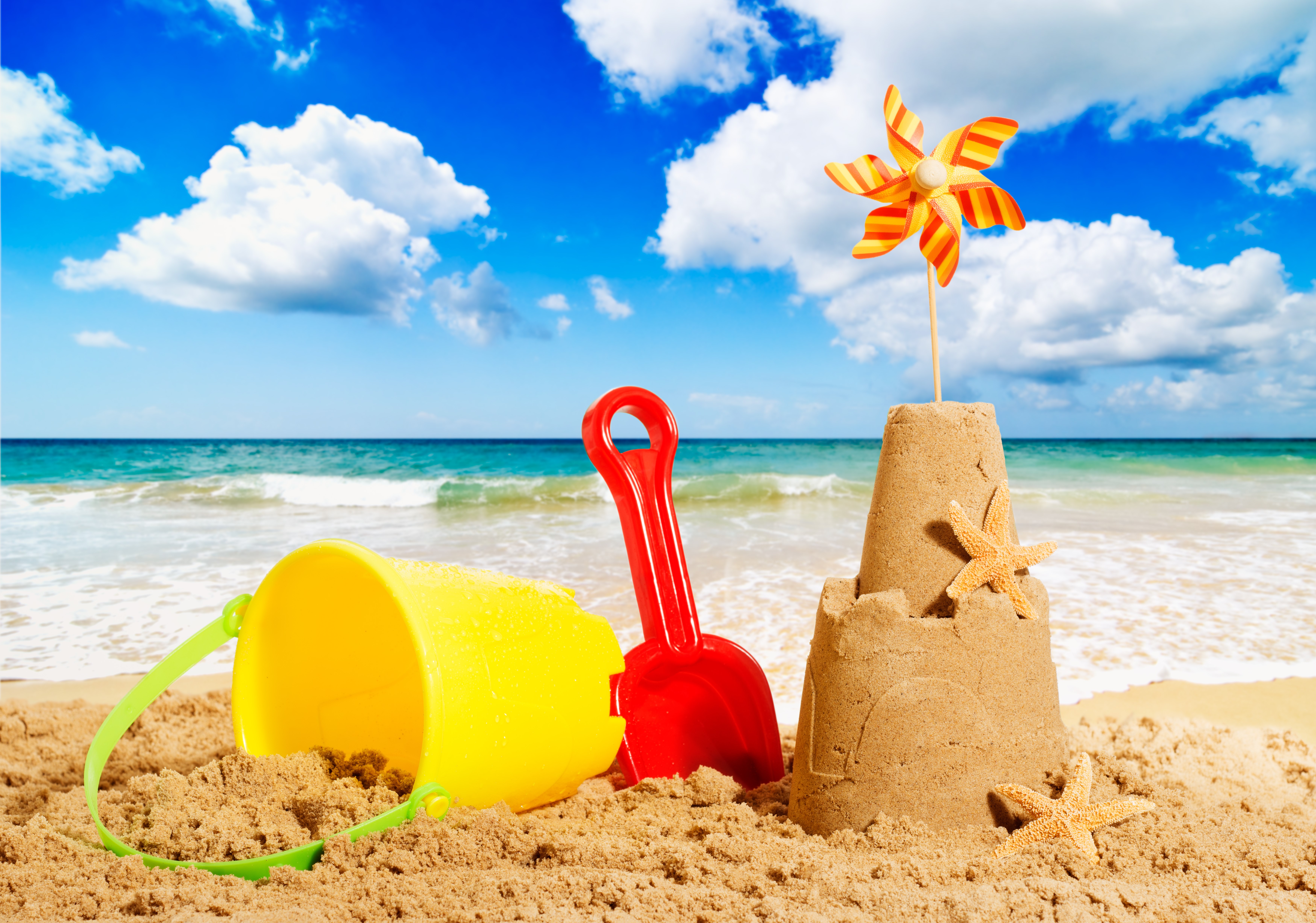 Beach toys and sandcastle on a sunny day HD Wallpaper