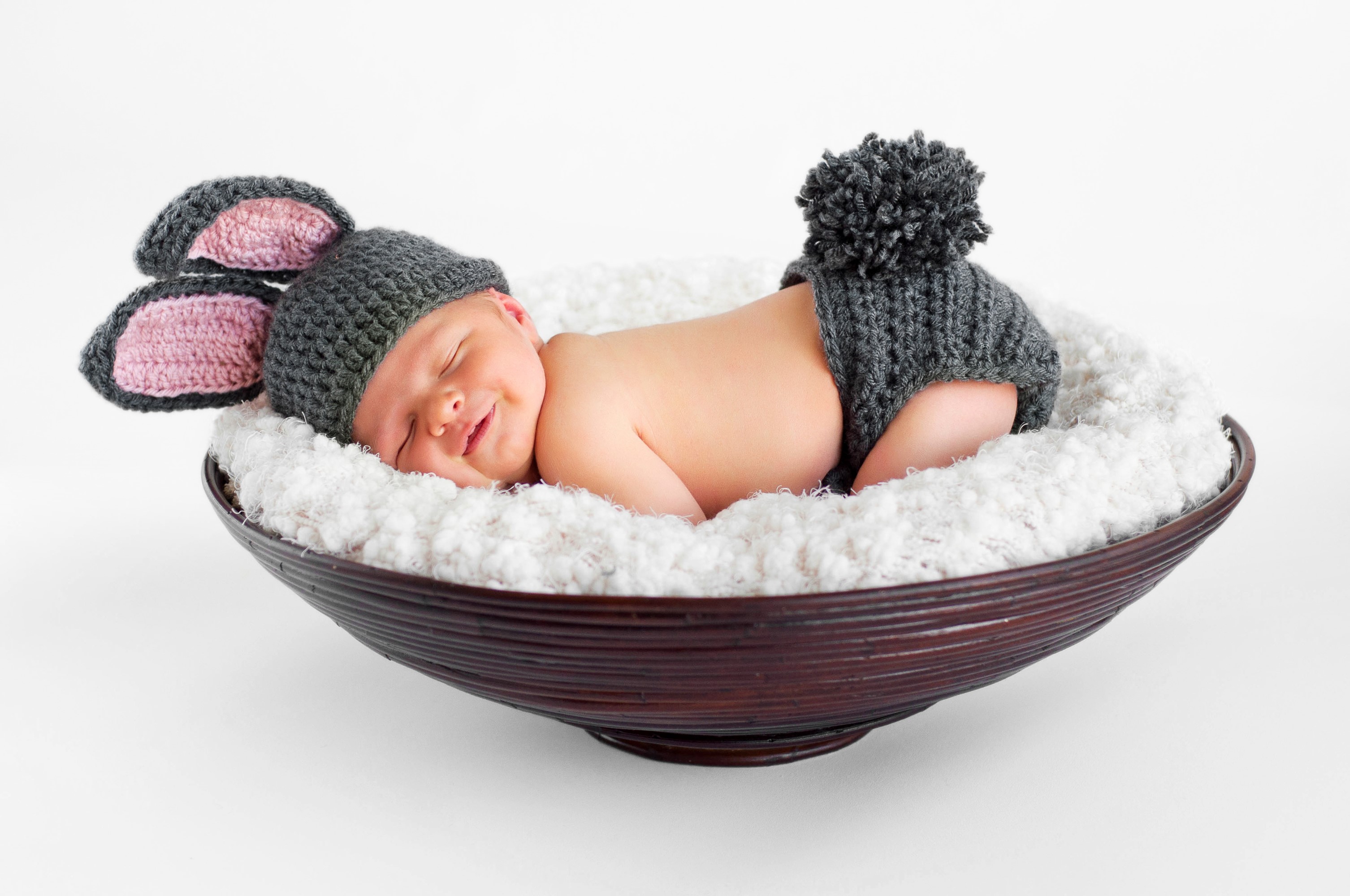 Newborn baby in bunny costume sleeping in a bowl HD Wallpaper