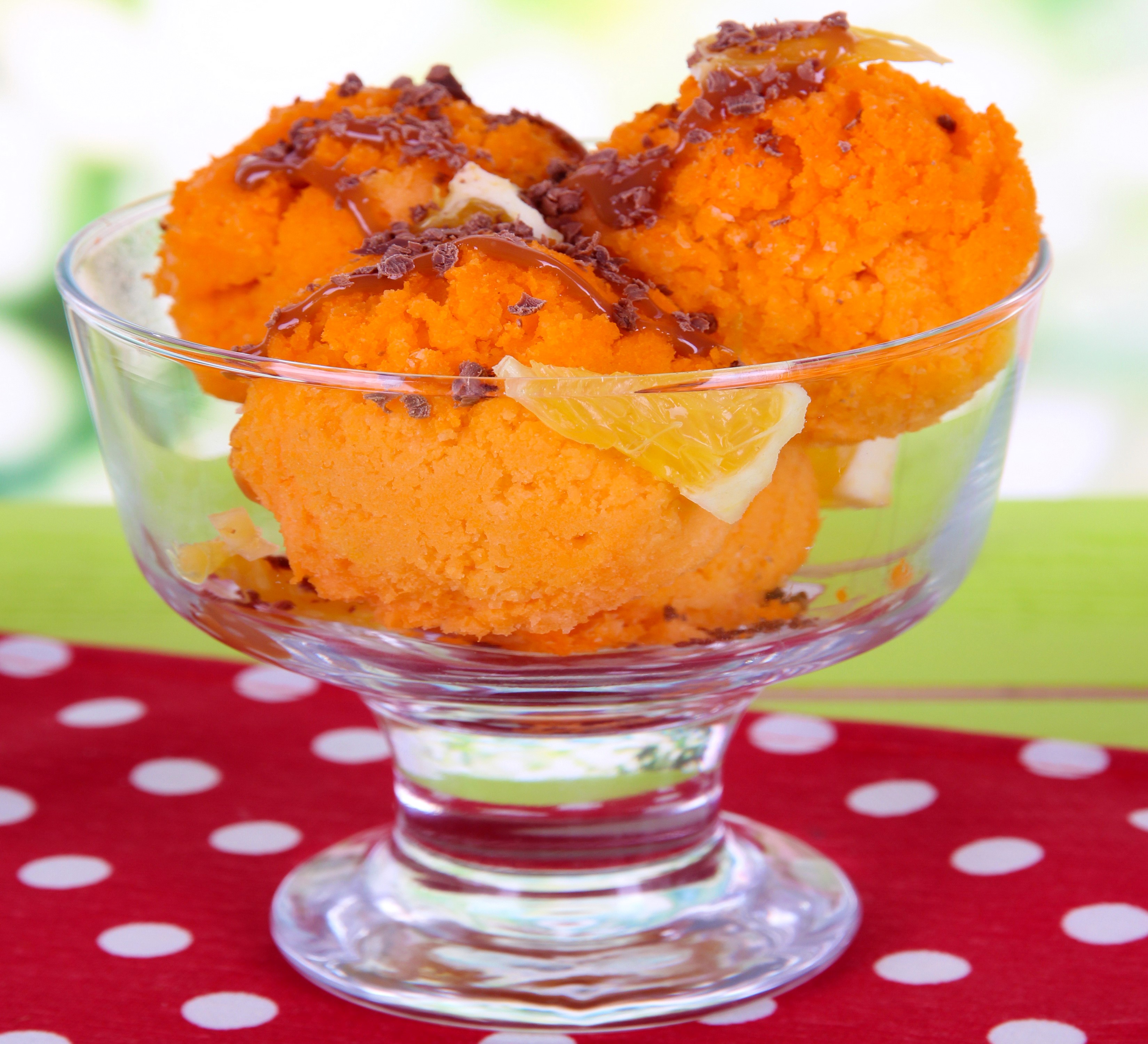 Orange ice cream scoops in a glass bowl with chocolate shavings and orange slices HD Wallpaper