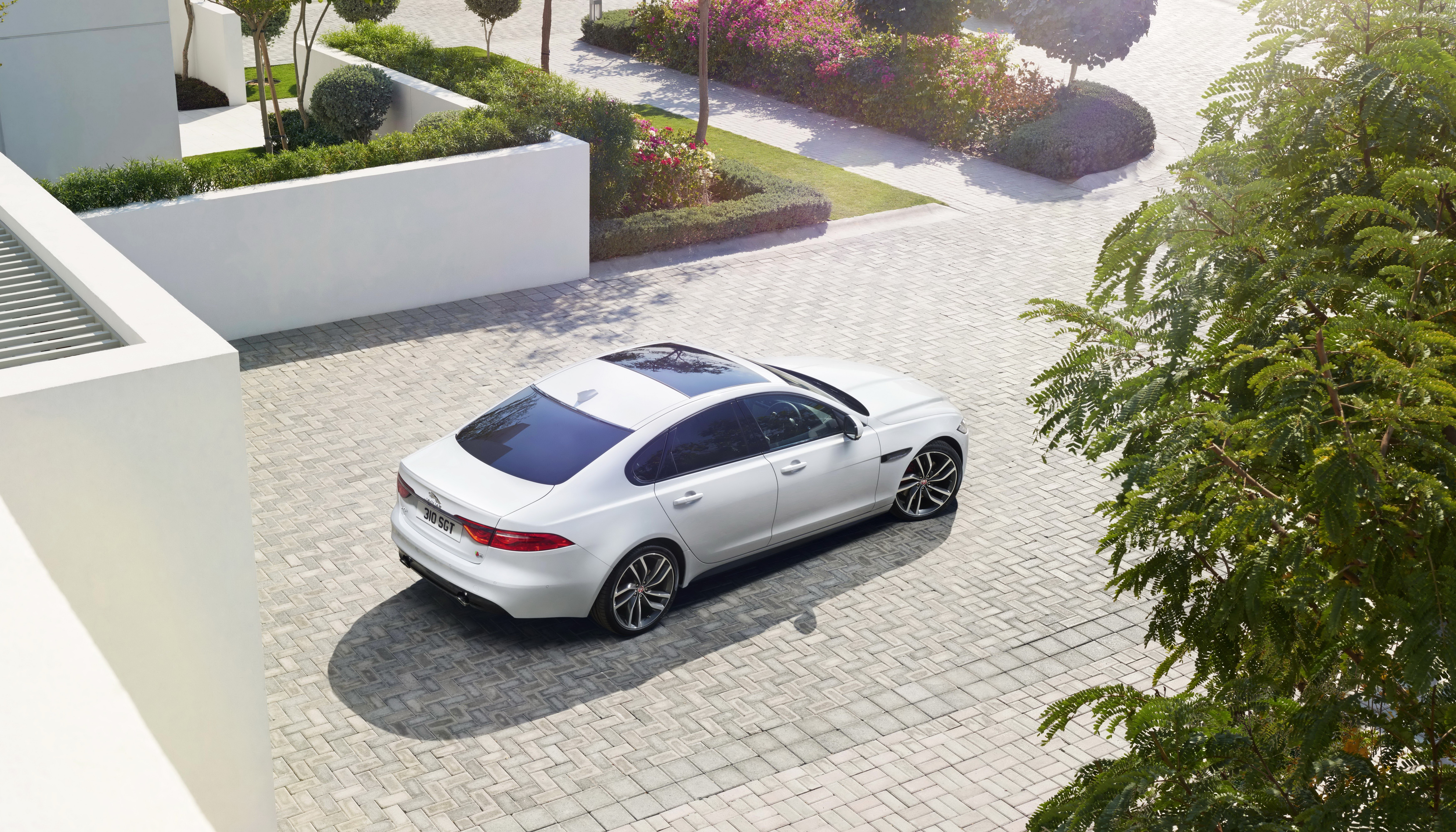 White Jaguar XF parked on a paved driveway HD Wallpaper